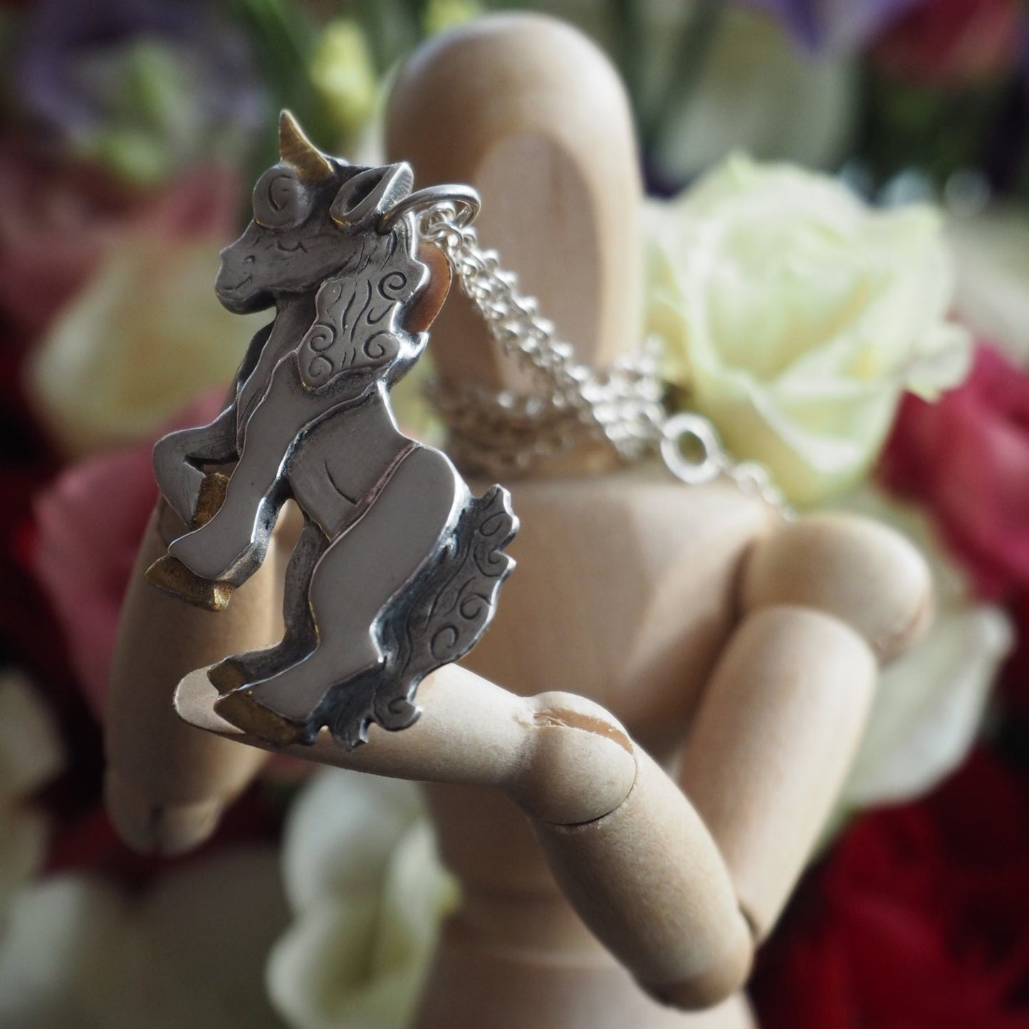 A gorgeous rearing unicorn, handmade in chunky fine silver with a 24k gold enhanced horn and hooves.
