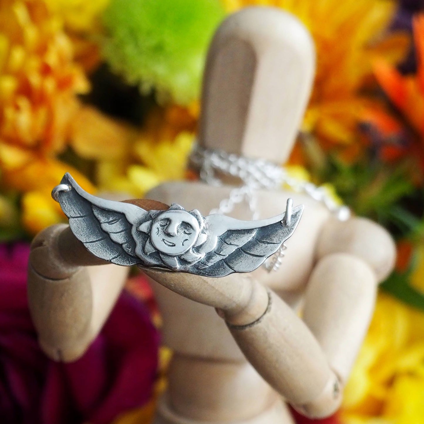 A glorious tattoo inspired winged sun necklace hand made fine silver on a sterling silver chain.