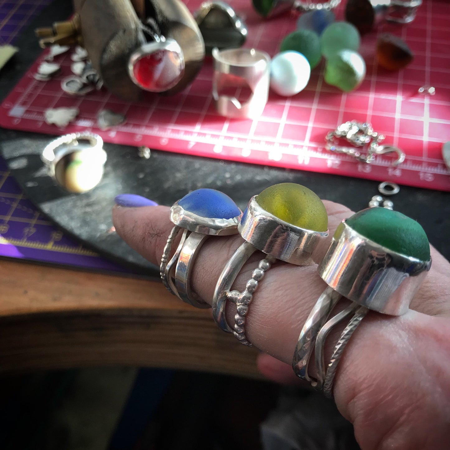 A totally unique sterling silver ring with green and red sea glass marble set on hand constructed band.