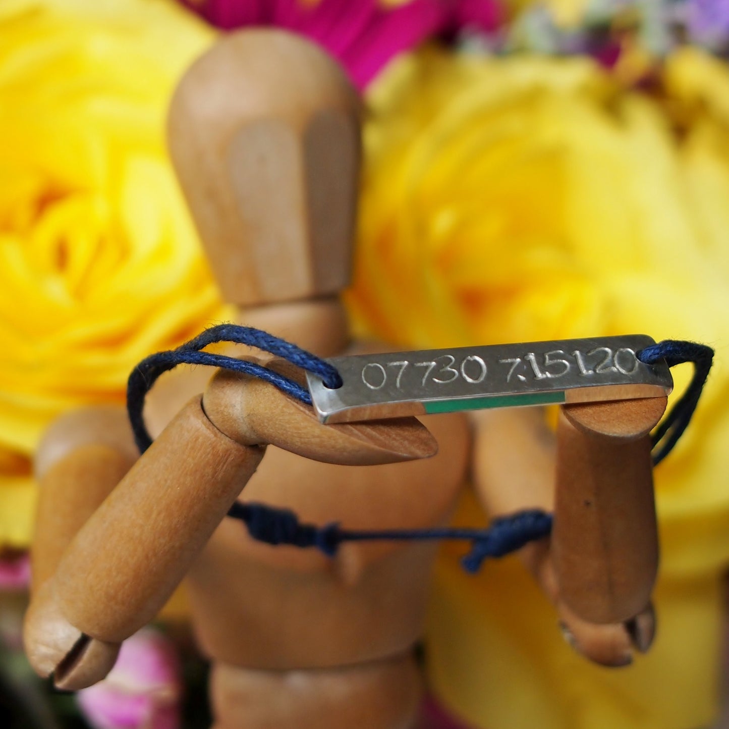 A custom children's security bracelet , hand stamped on chunky sterling silver on waxed cotton.