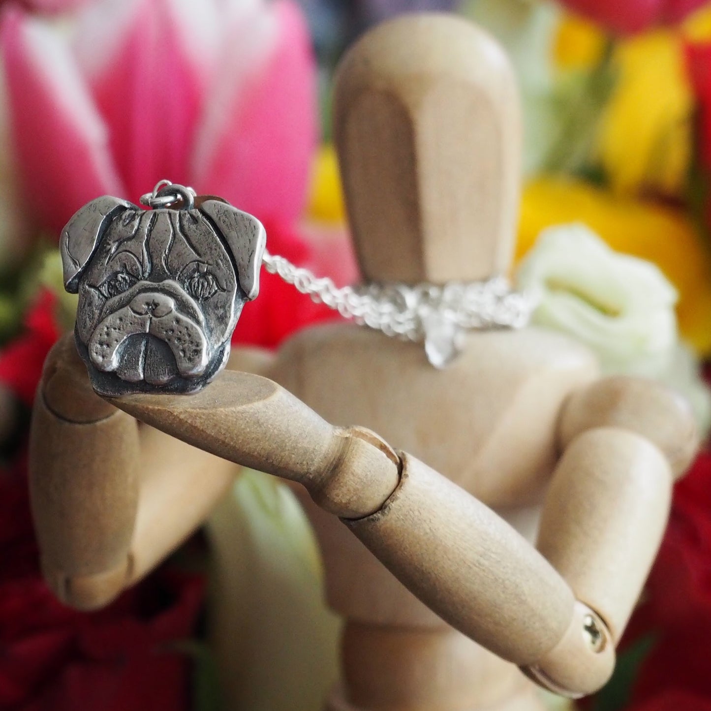 A delightful hand made fine silver pug dog pendant on a sterling silver chain.