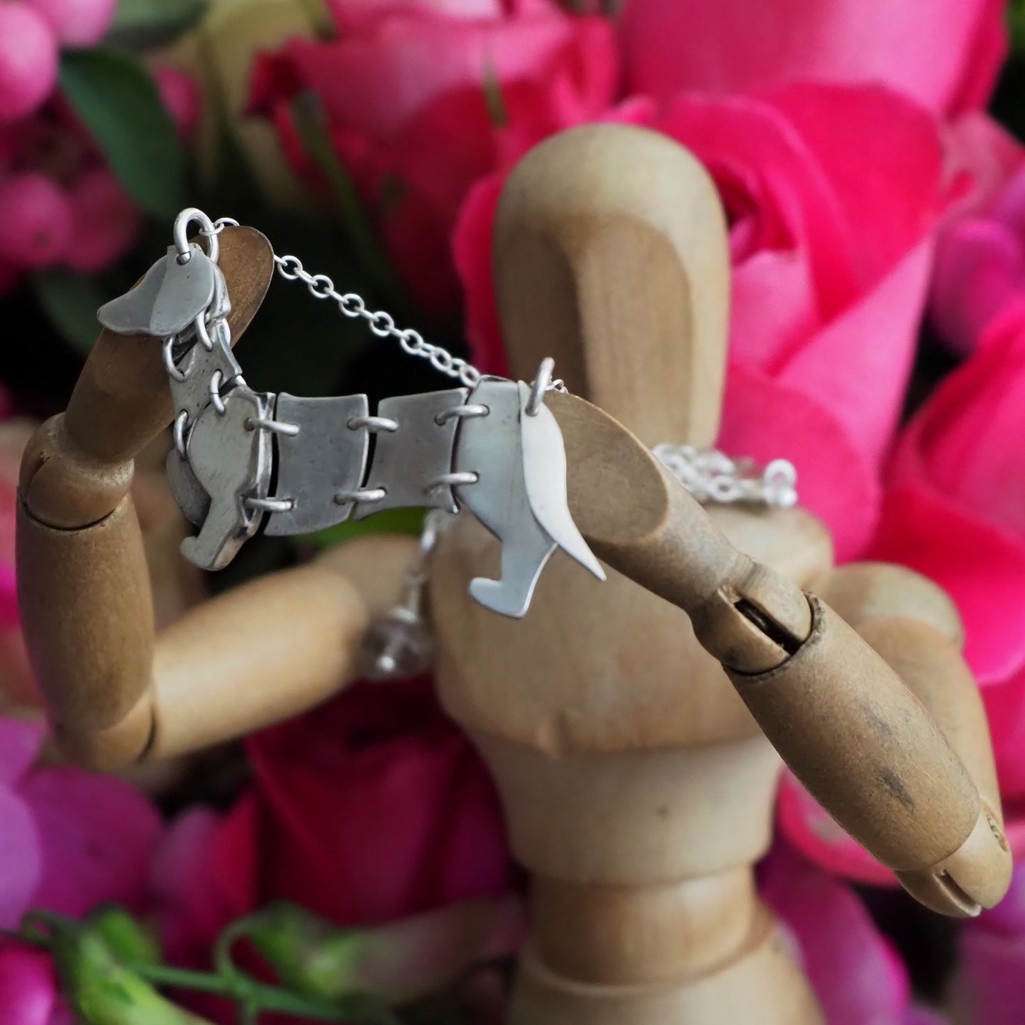 A gorgeous hand made fine silver moving articulated dachshund dog necklace on a sterling silver chain.