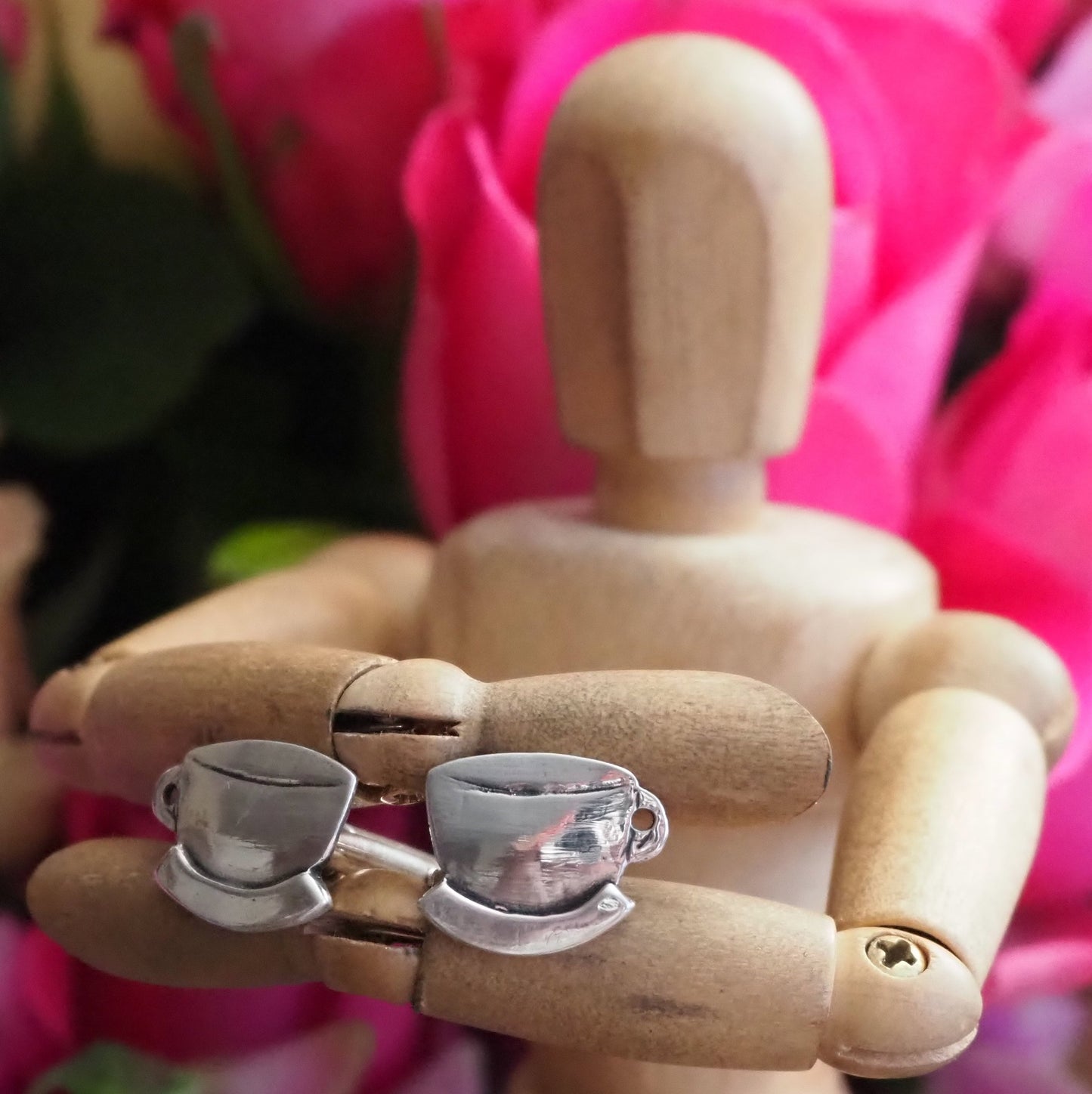 A pair of handmade fine silver tea cup cufflinks, perfect for tea for two. Finished with a sterling silver bar.