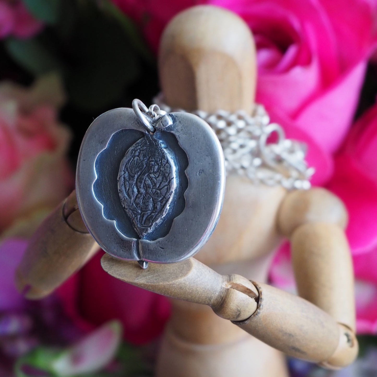 A lovely simple fine silver half peach pendant on a long chunky sterling silver chain.