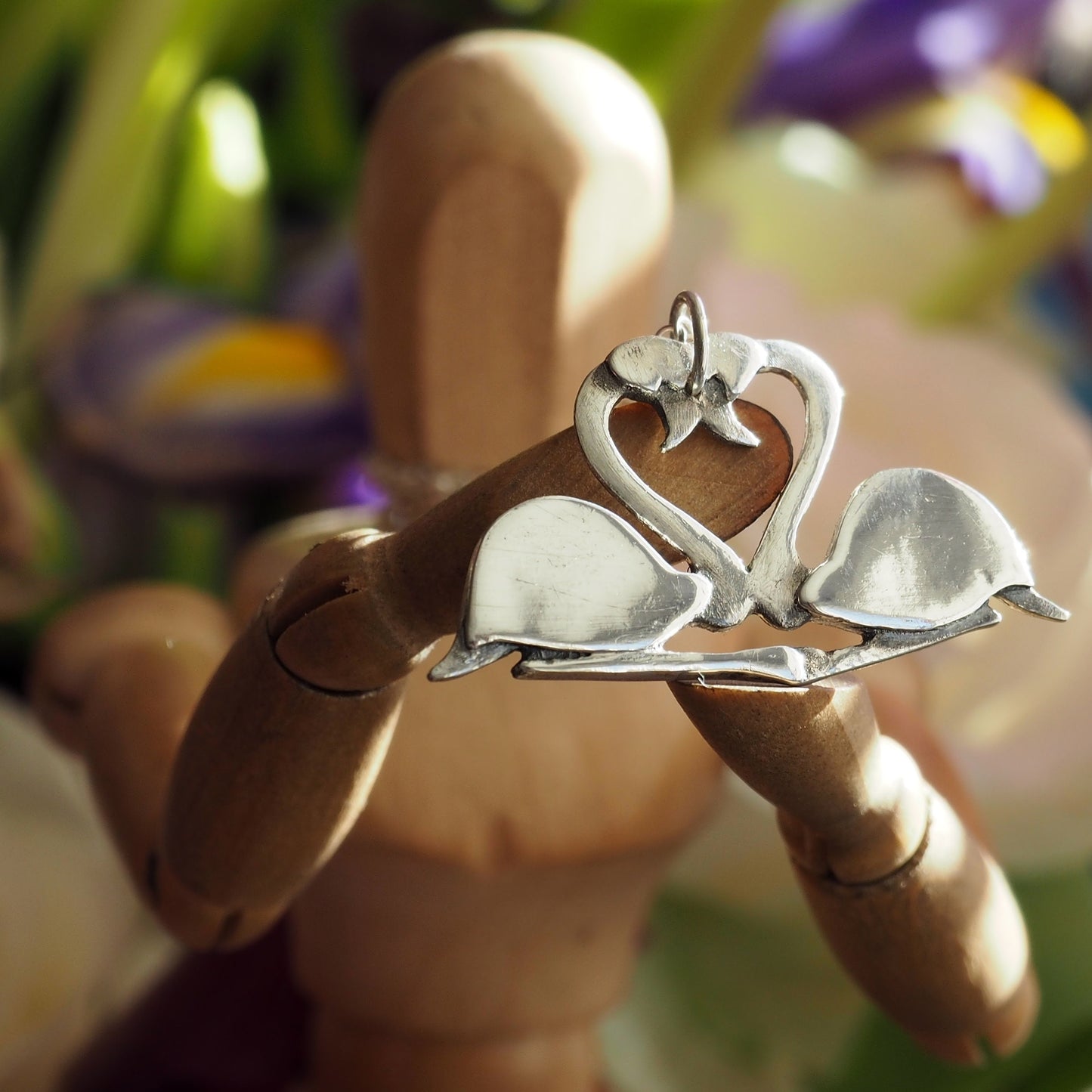 A pair of beautifully simple sitting fine silver flamingos pendant, handmade and hung on a sterling silver chain.