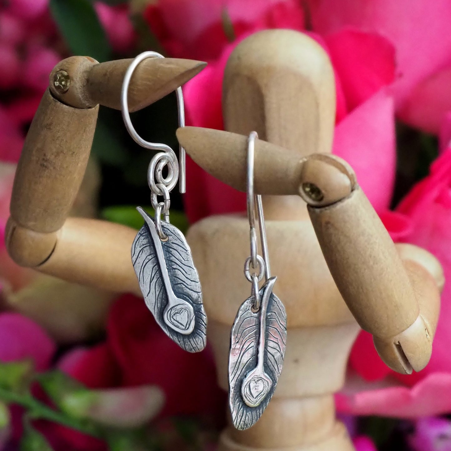 A pair of beautifully simple handmade unique fine silver peacock feather earrings on hand made sterling silver wires.