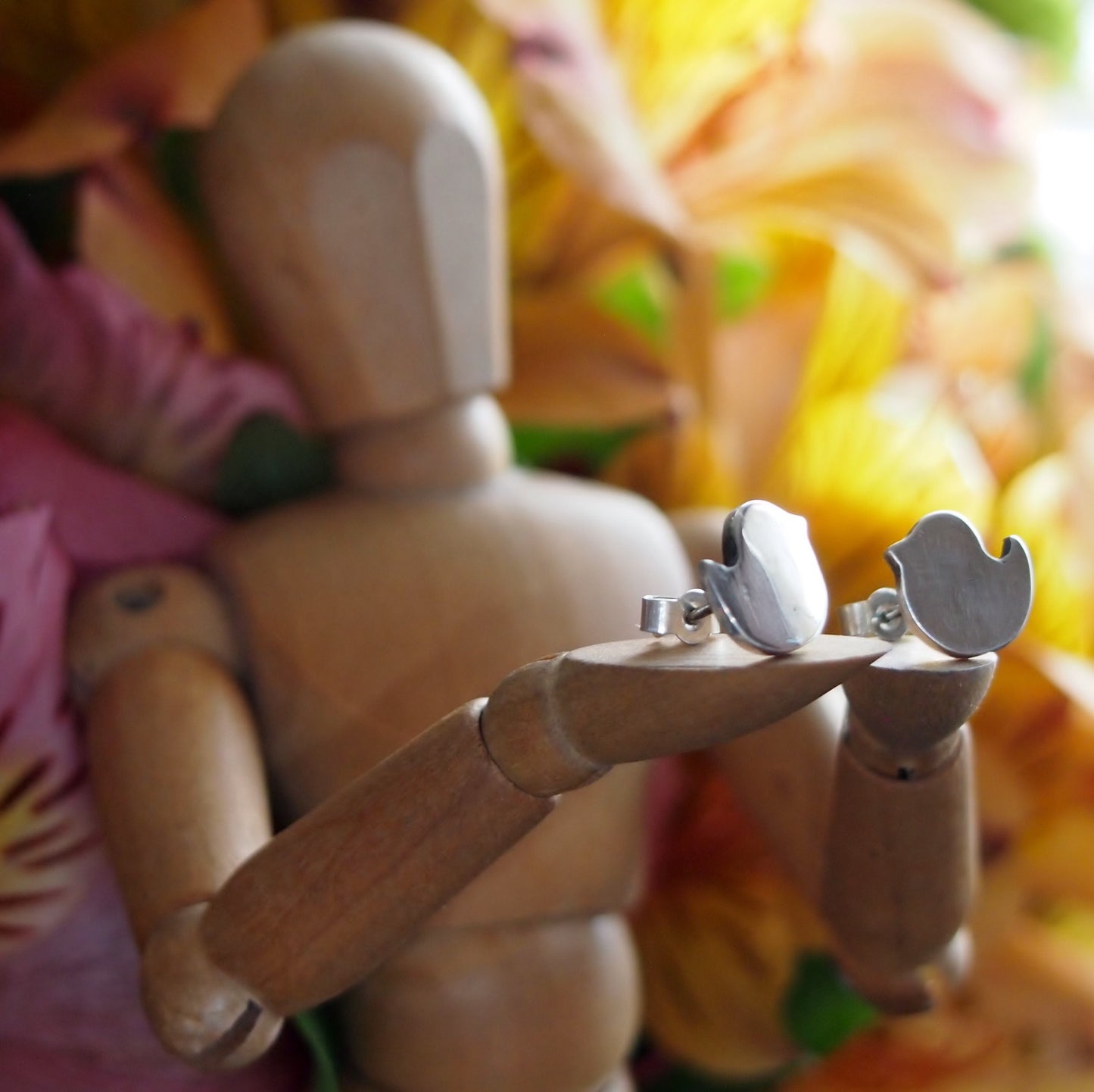A beautifully simple pair of tiny bird stud earrings handmade in fine silver