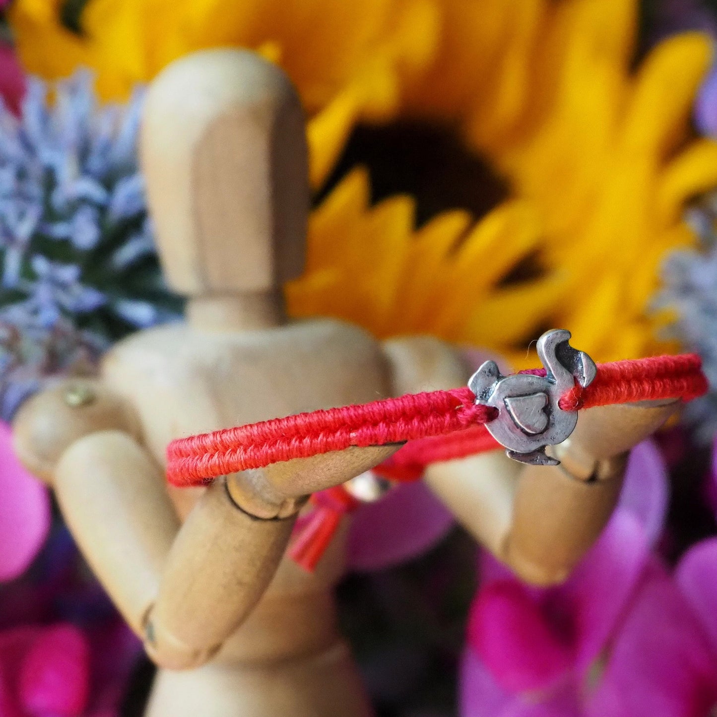 A pretty red leather and cotton friendship bracelet with a lovely handmade fine silver dodo, finished with a sterling silver bead.