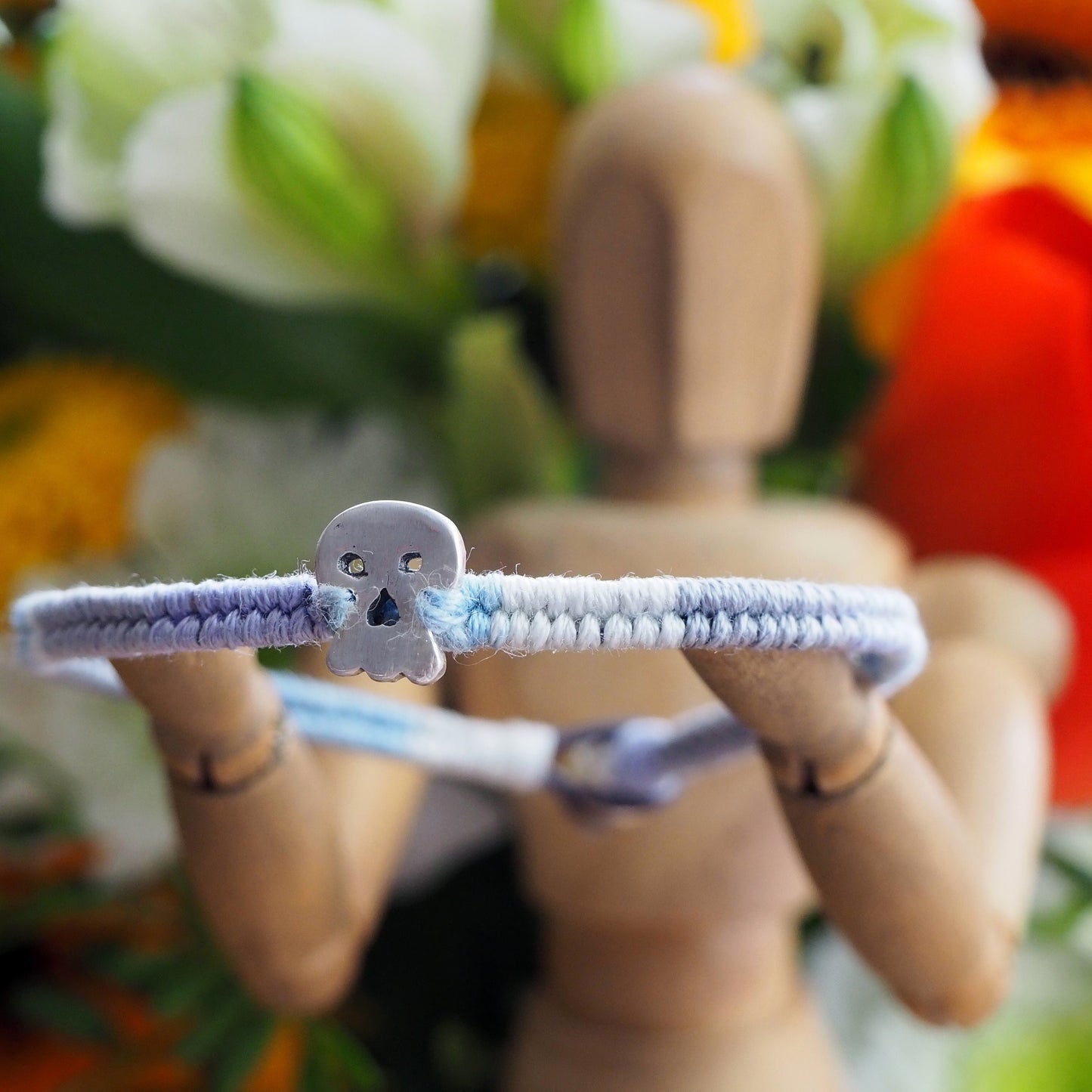 A wonderfully gothic tiny unique fine silver skull on a blues, lilac and greys leather, sterling silver and cotton friendship bracelet.