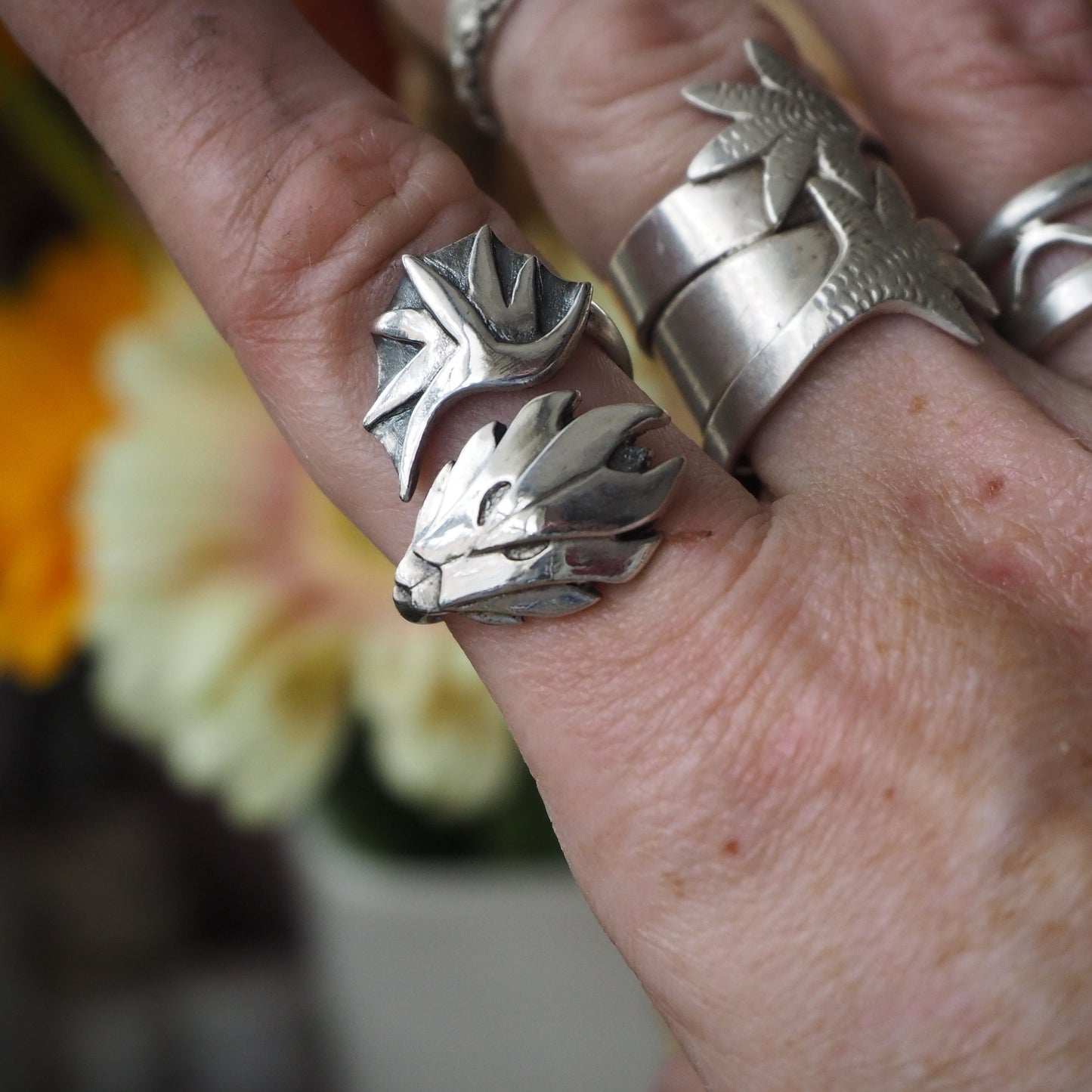 A stunning unique handmade dragon and wing ring in fine silver on an adjustable sterling silver band.