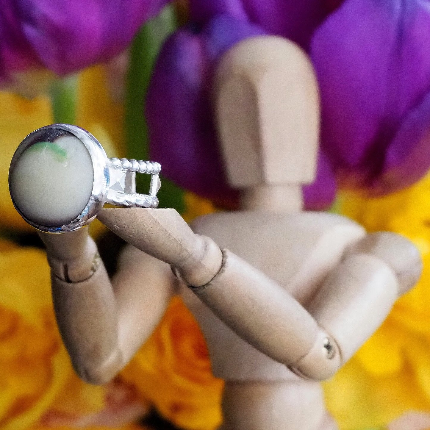 A beautiful sterling silver ring with brown and green sea glass marble set on and hand constructed band.