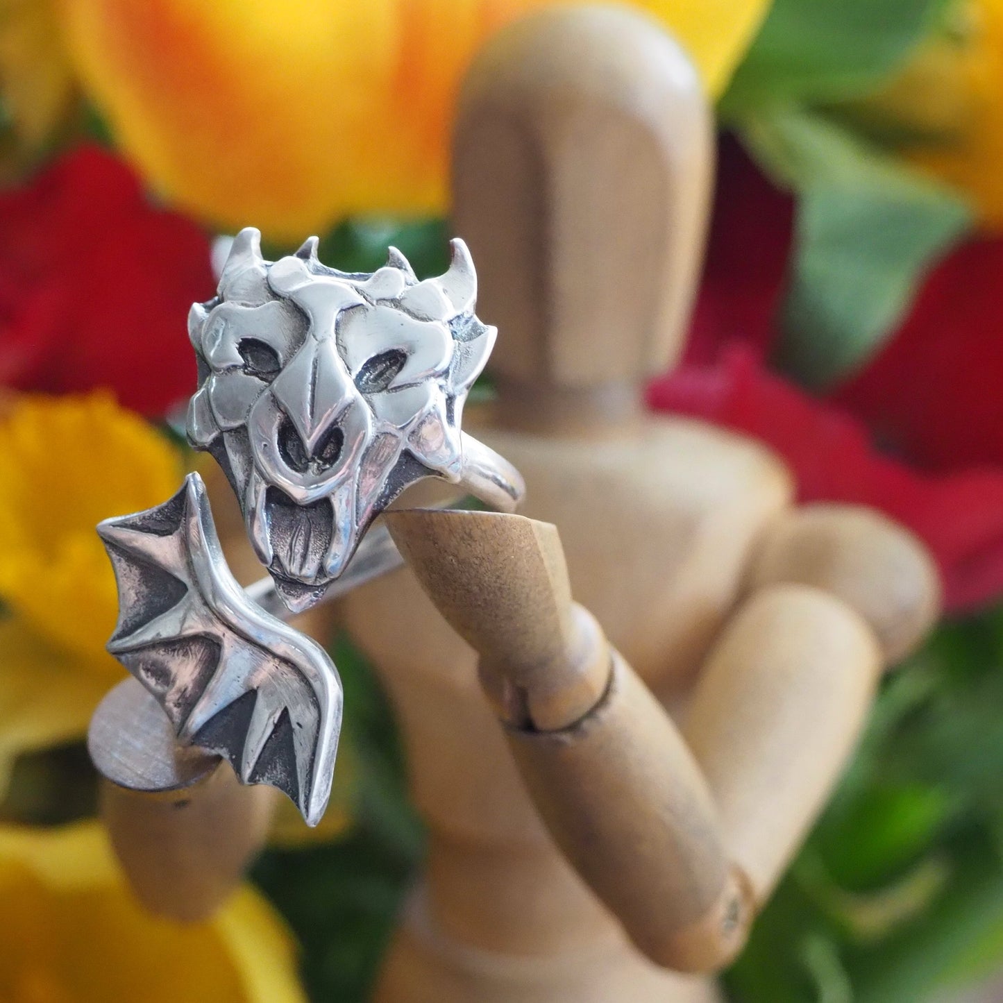 A beautiful unique handmade dragon and wing ring in fine silver on an adjustable sterling silver band.