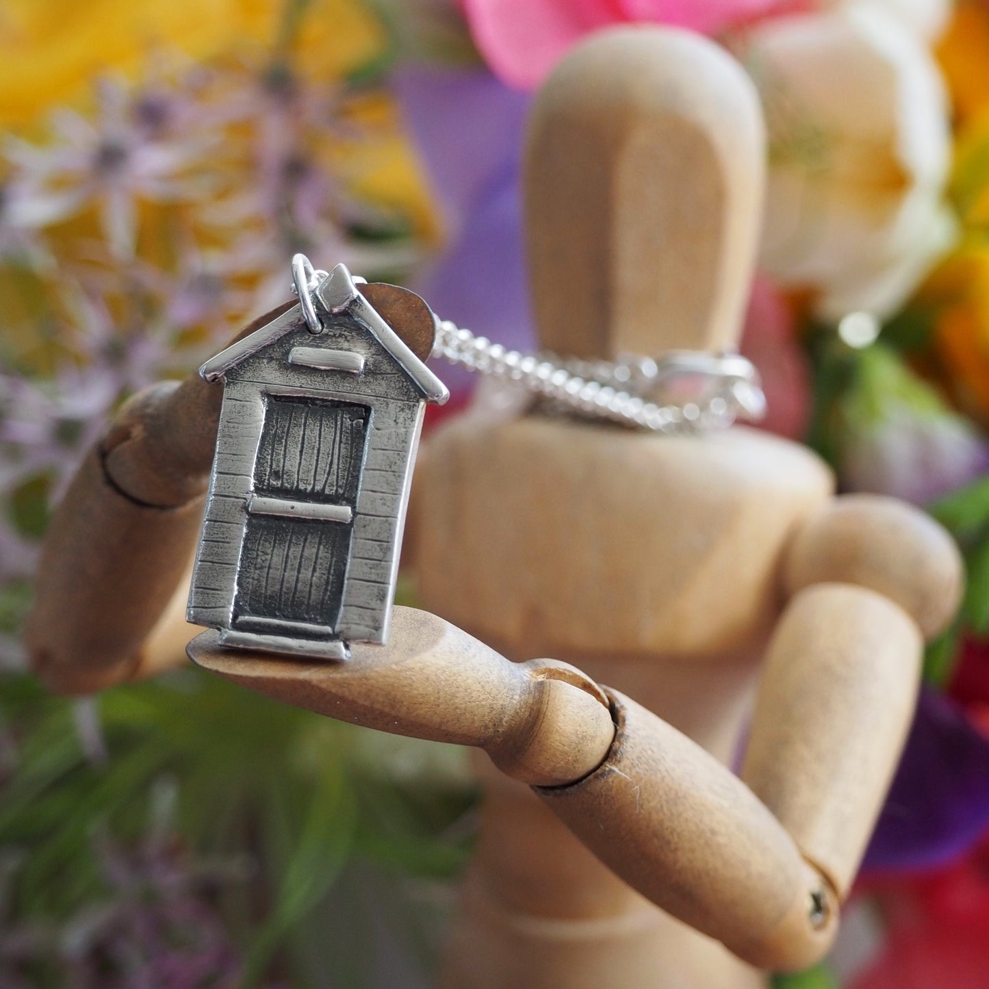 A super cute little eco friendly fine silver beach hut pendant hung on a sterling silver chain.