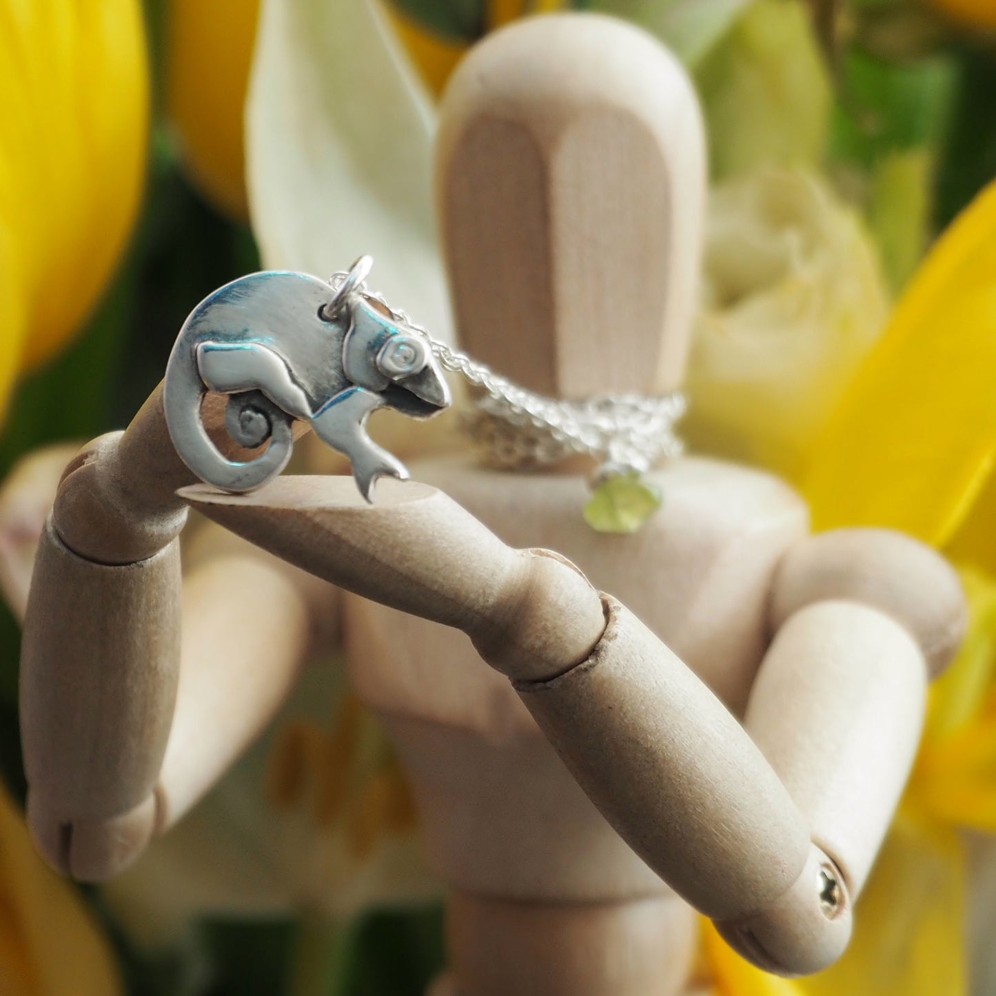 A sweet little fine silver chameleon pendant hung on a sterling silver chain.