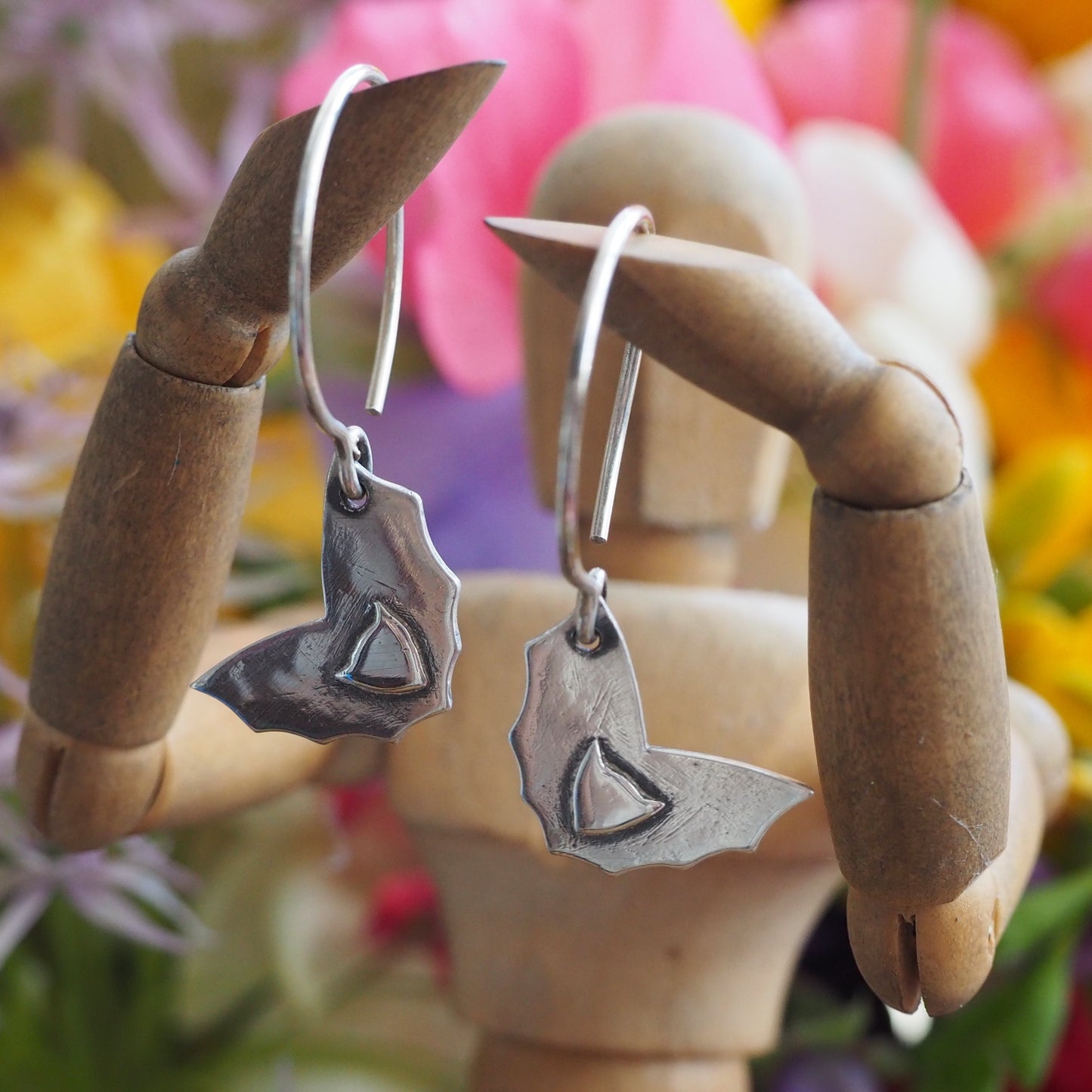 A pair of delightfully simple eco friendly fine silver bat earrings hung on handmade sterling silver wires.