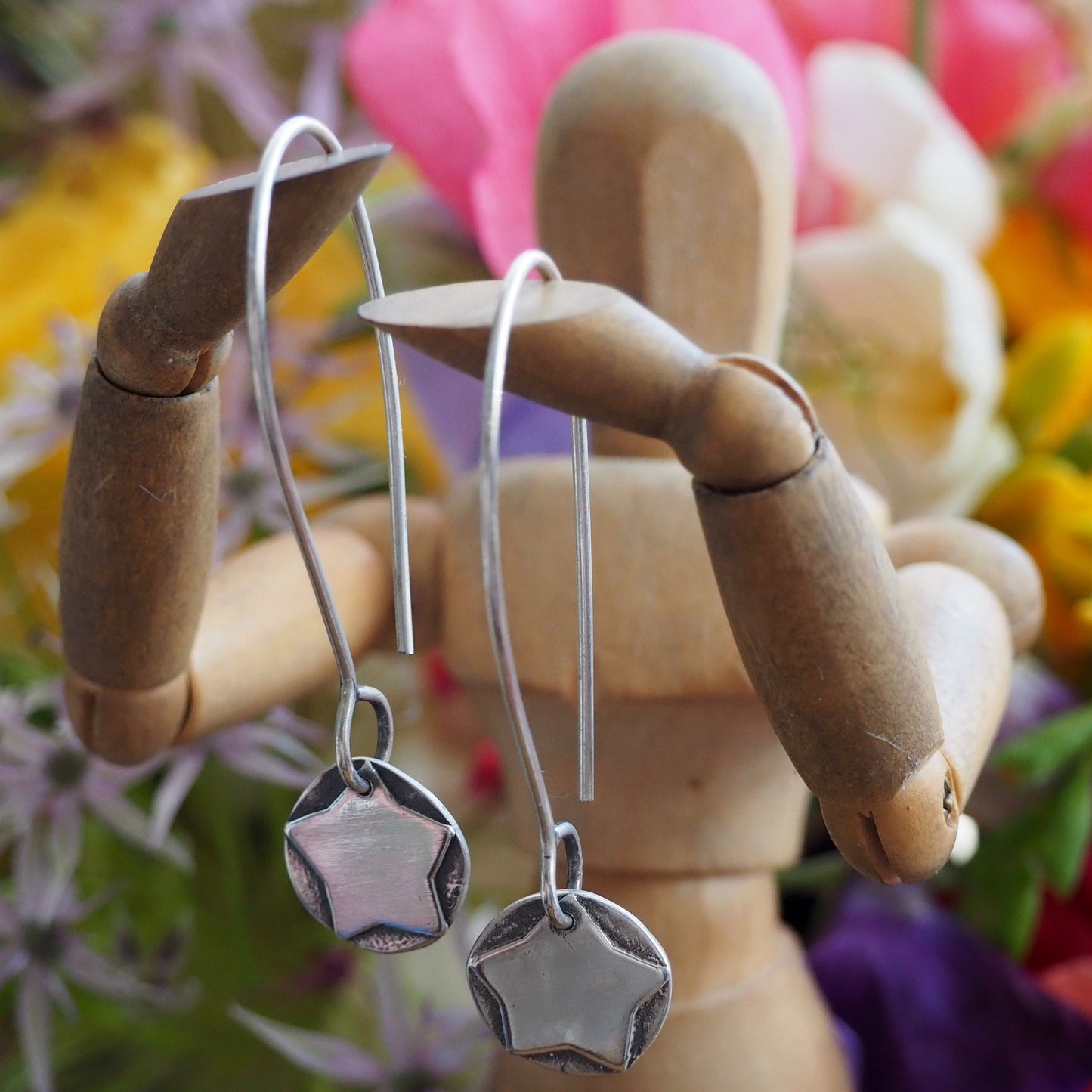 A beautiful simple handmade pair of eco friendly fine silver star on disc earrings on long sterling silver wires