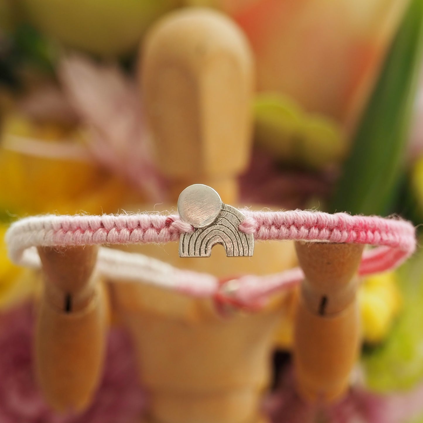 A beautiful small sized soft pinks leather and cotton friendship bracelet with a simple tiny fine silver moon and rainbow