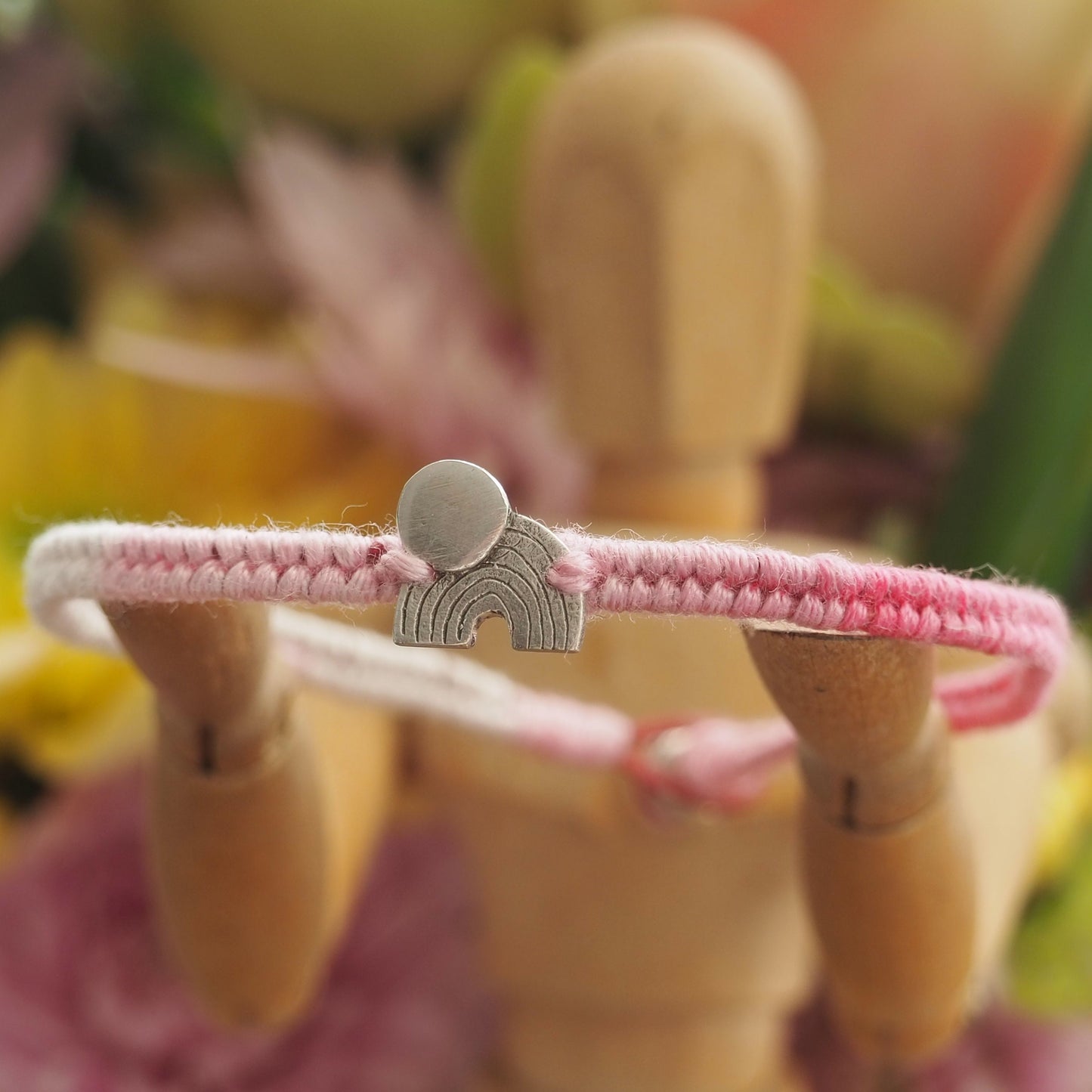 A beautiful small sized soft pinks leather and cotton friendship bracelet with a simple tiny fine silver moon and rainbow