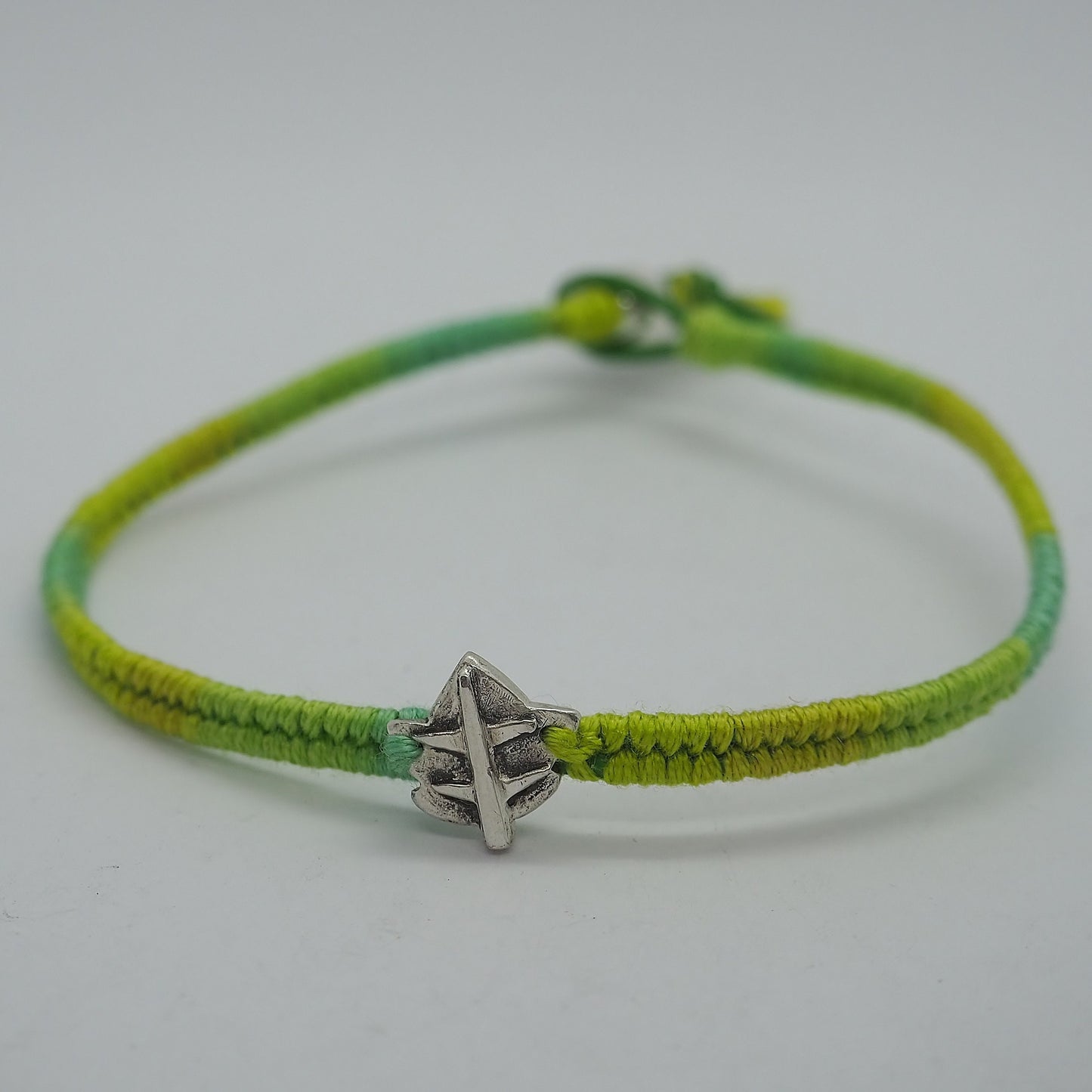 A delightful handmade fine silver ivy leaf on a shades of green friendship bracelet in leather, sterling silver and cotton.