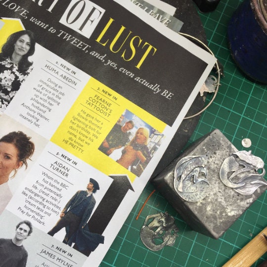 A pair of gorgeous tiny owl earrings handmade out of fine silver on sterling silver posts.