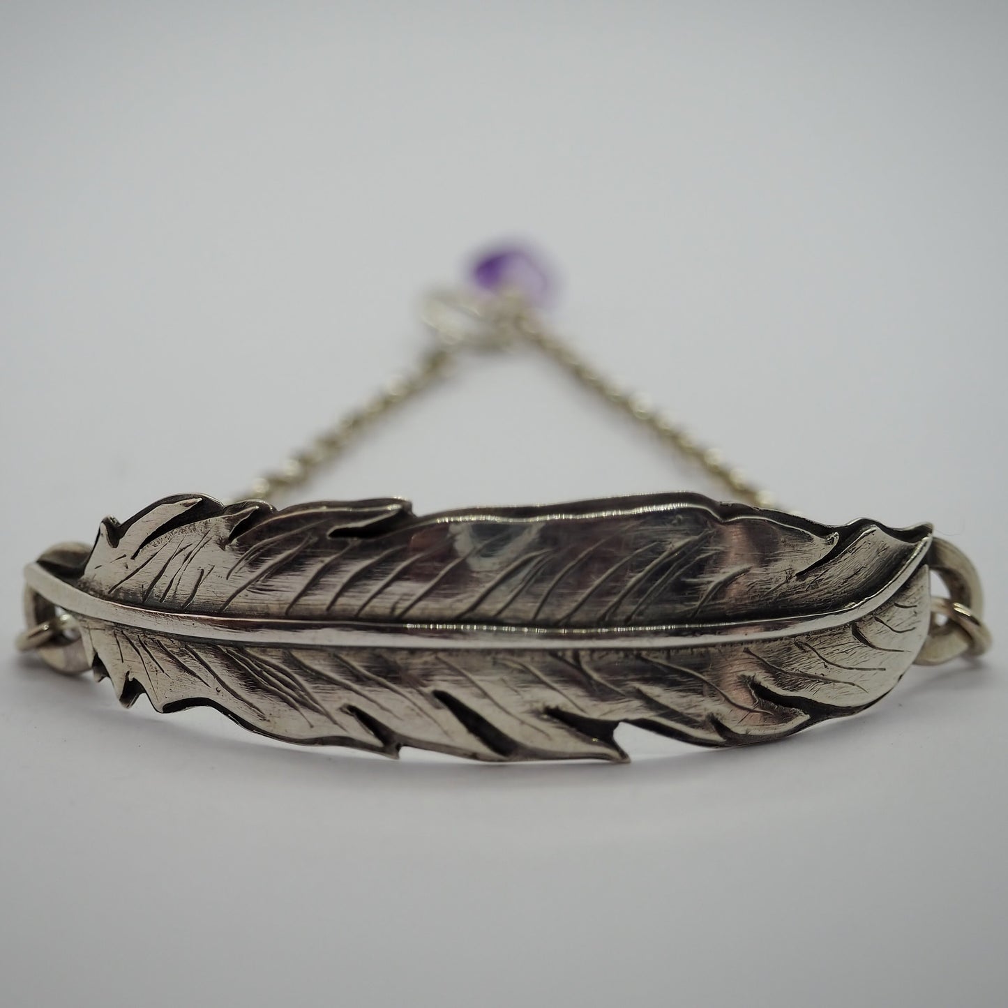A stunning handmade fine silver feather backed with hand cut sterling silver on a sterling silver chain bracelet.