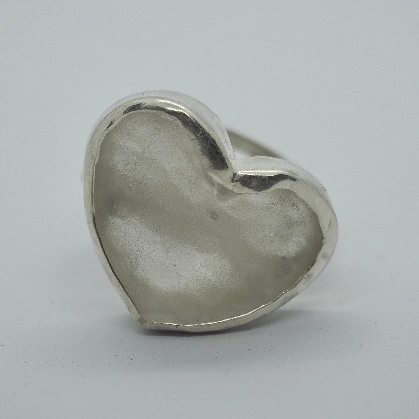 A simple unique heart ring with ‘sea glass’ from an upcycled Mermaid gin bottle set in recycled sterling silver on an adjustable band.