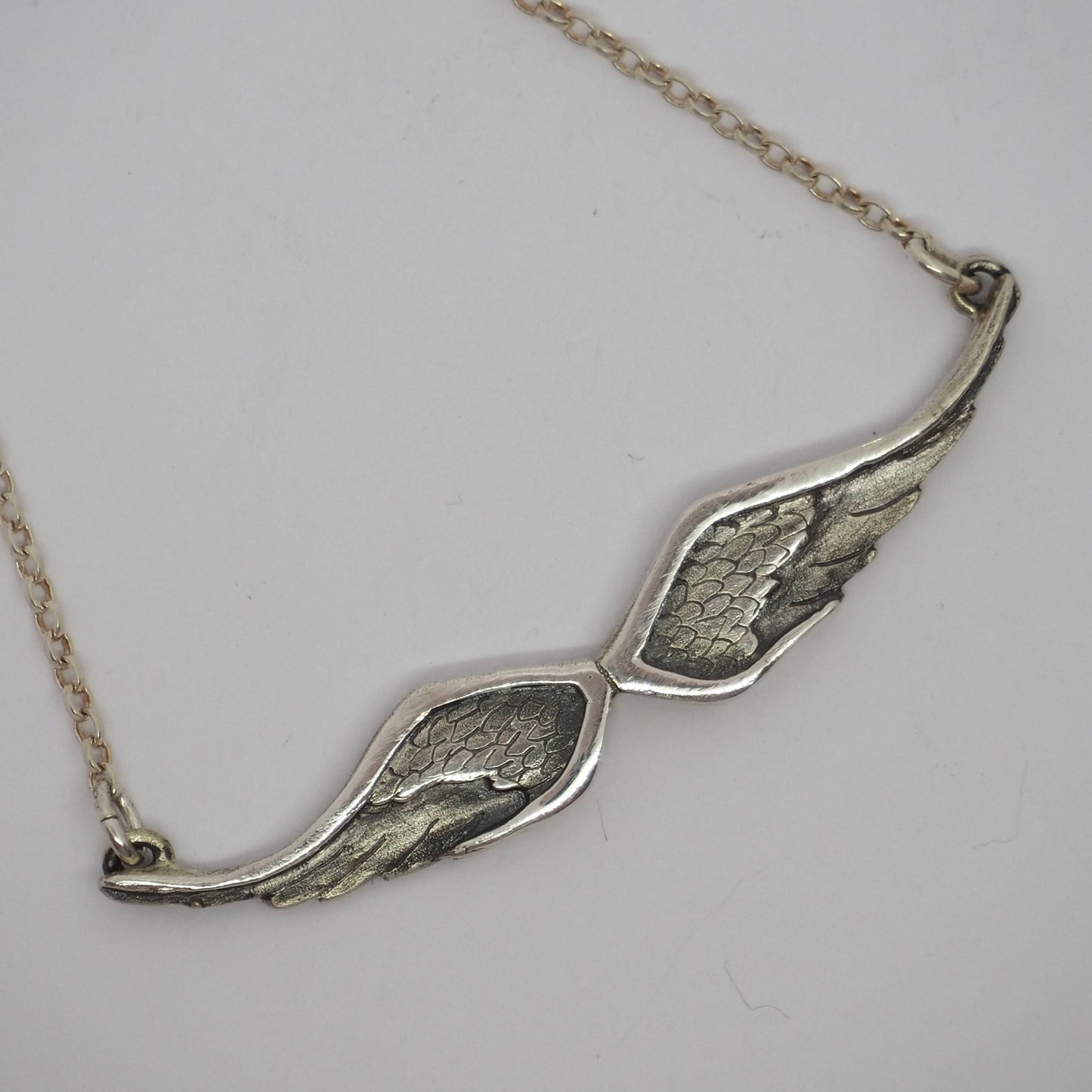A gorgeous simple fine silver pair of handmade  angel wings necklace on a sterling silver chain.