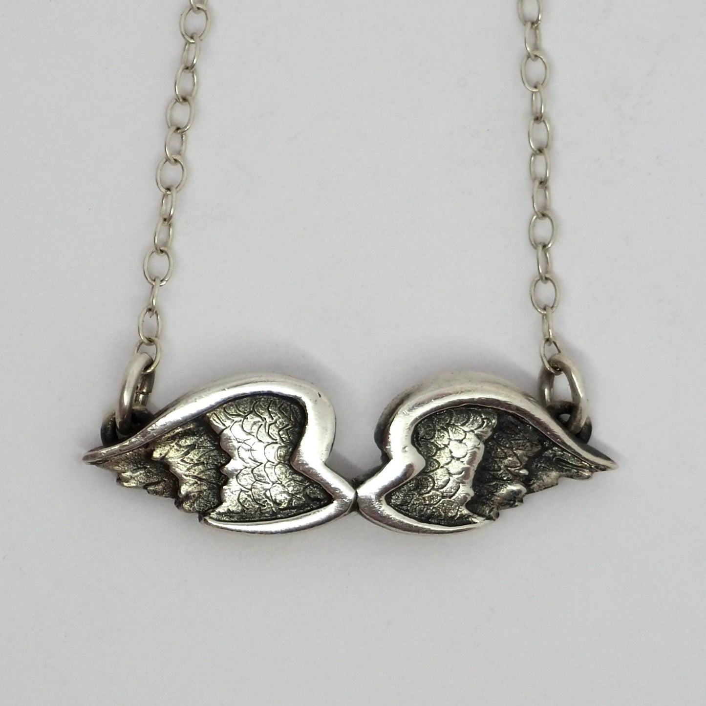 A gorgeous fine handmade silver Angel Wings necklace hung on a sterling silver chain.