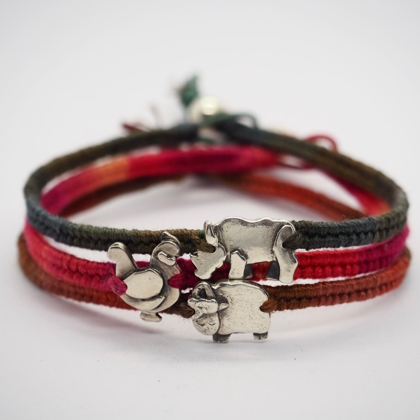 A pretty reddy orange leather and cotton friendship bracelet with a handmade fine silver chicken, finished with a sterling silver bead.