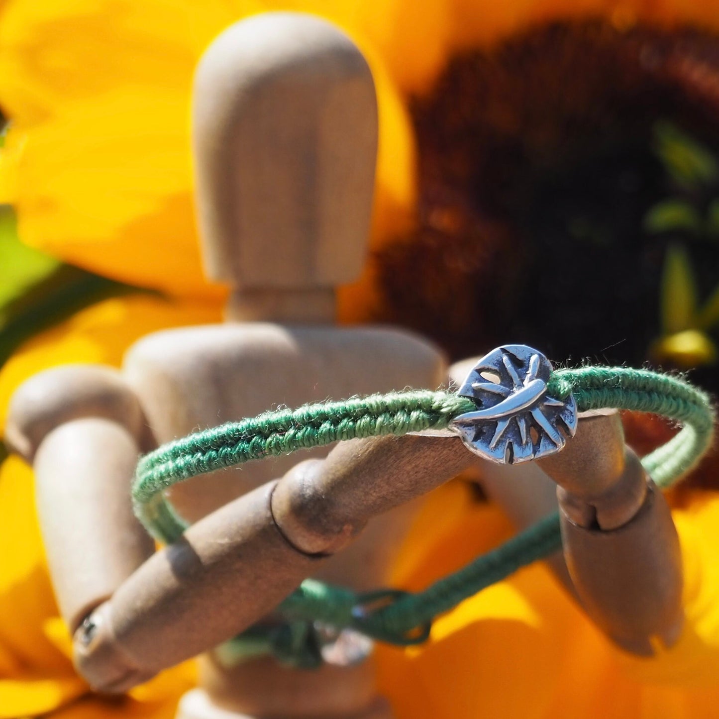 A gorgeous olive green friendship bracelet in leather, cotton and sterling silver with a stunning handmade fine silver monstera leaf.