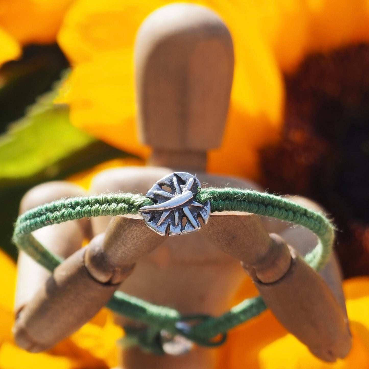 A gorgeous olive green friendship bracelet in leather, cotton and sterling silver with a stunning handmade fine silver monstera leaf.