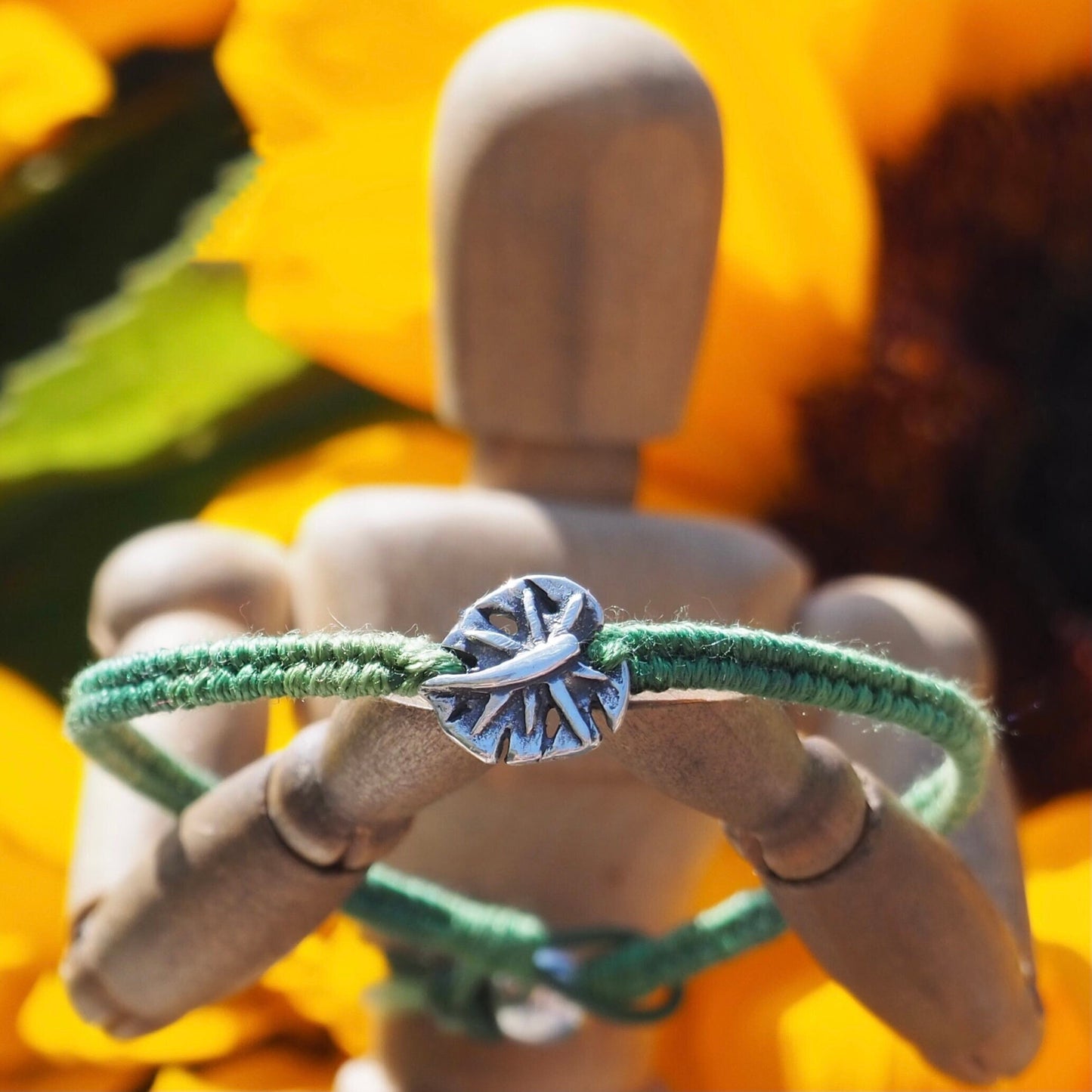 A gorgeous olive green friendship bracelet in leather, cotton and sterling silver with a stunning handmade fine silver monstera leaf.