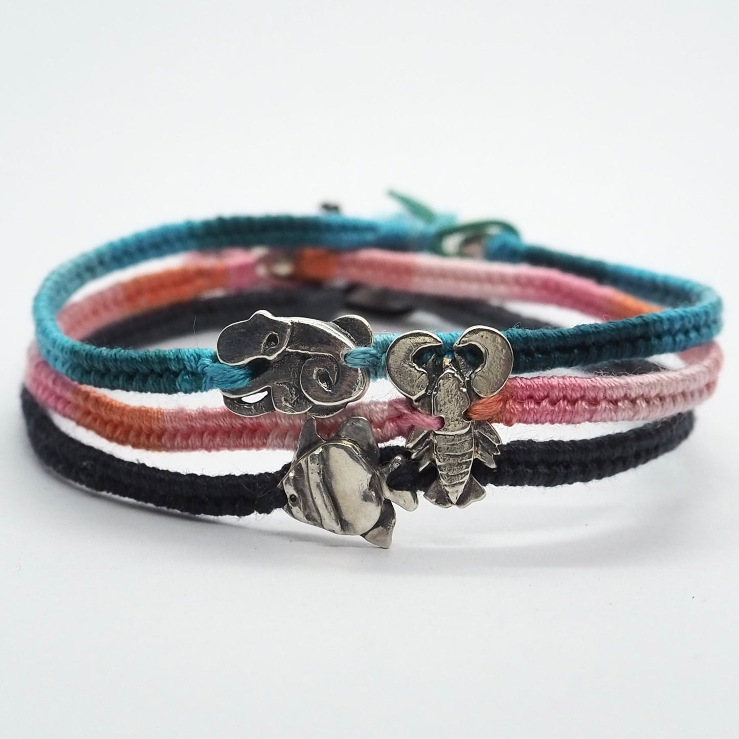 A pretty soft greys and black leather, cotton and sterling silver friendship bracelet with a tiny handmade fine silver tropical fish .