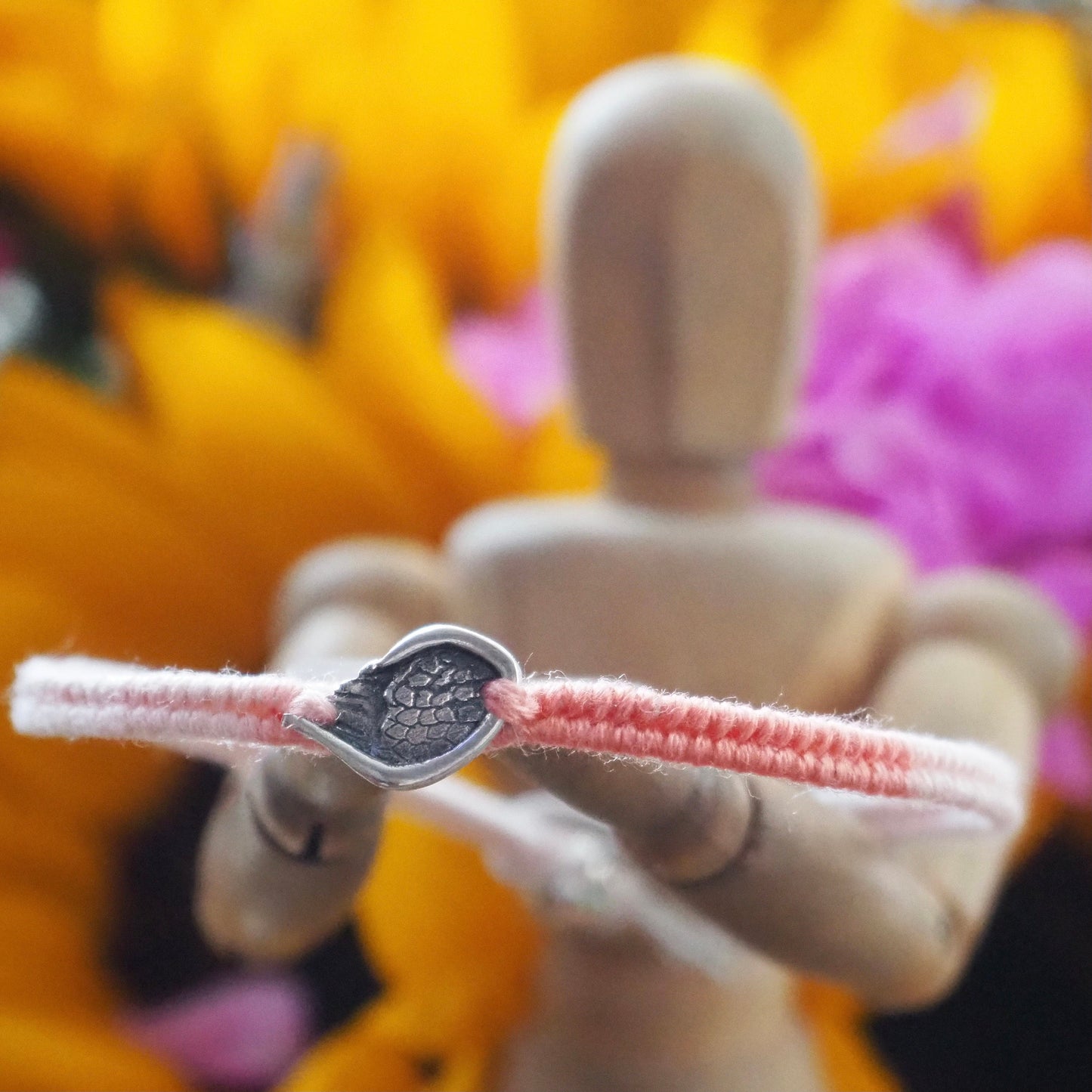 A gorgeous peachy leather, cotton and sterling silver friendship bracelet with a little handmade fine silver angel wing.