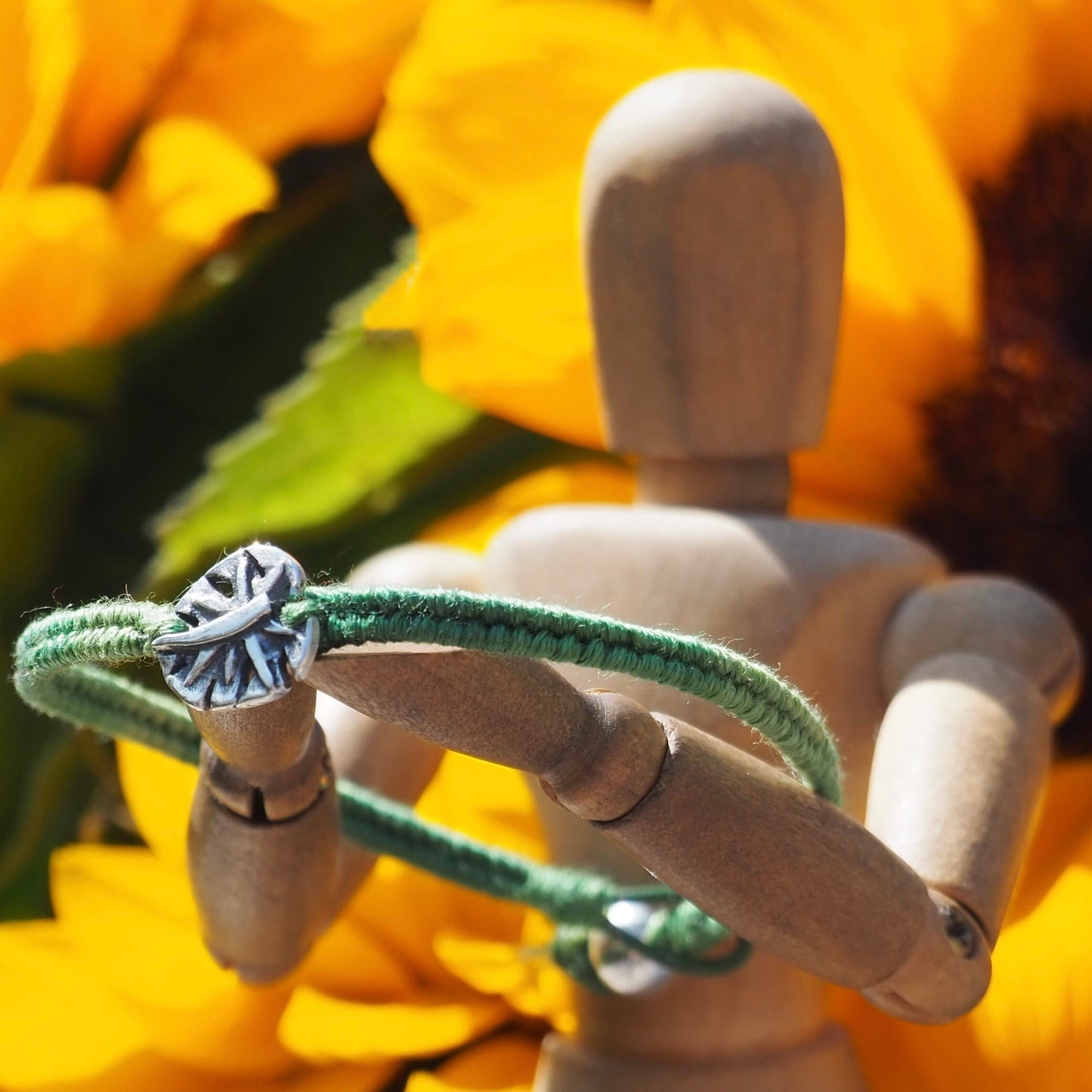 A gorgeous olive green friendship bracelet in leather, cotton and sterling silver with a stunning handmade fine silver monstera leaf.