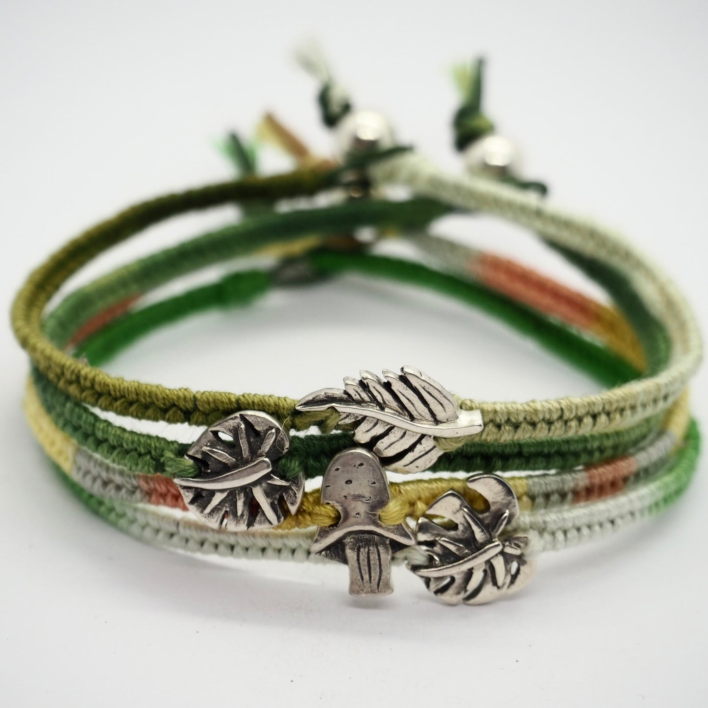 A gorgeous olive green friendship bracelet in leather, cotton and sterling silver with a stunning handmade fine silver monstera leaf.