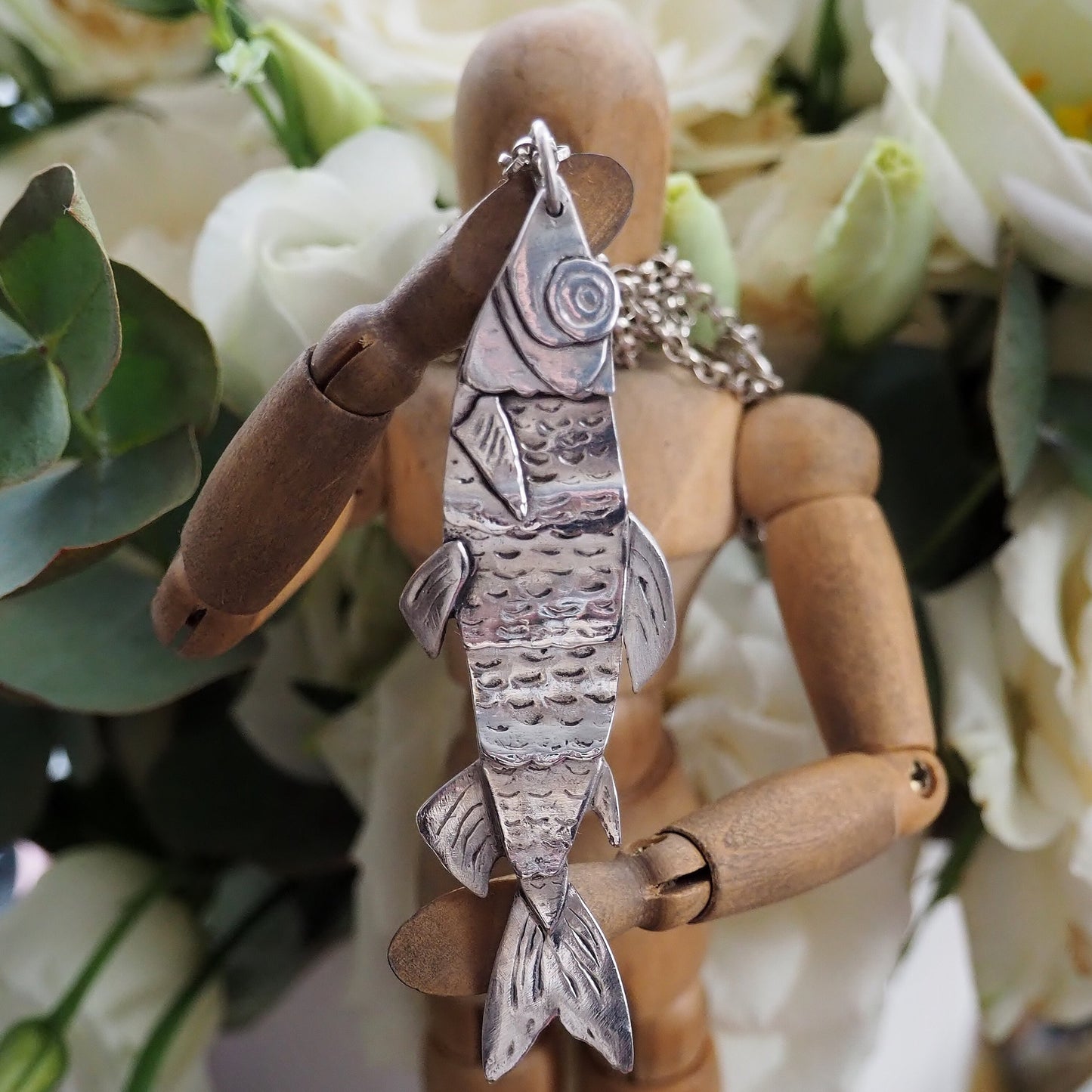 A beautiful jointed articulated fish pendant handmade in eco friendly fine silver, on a long sterling silver chain.