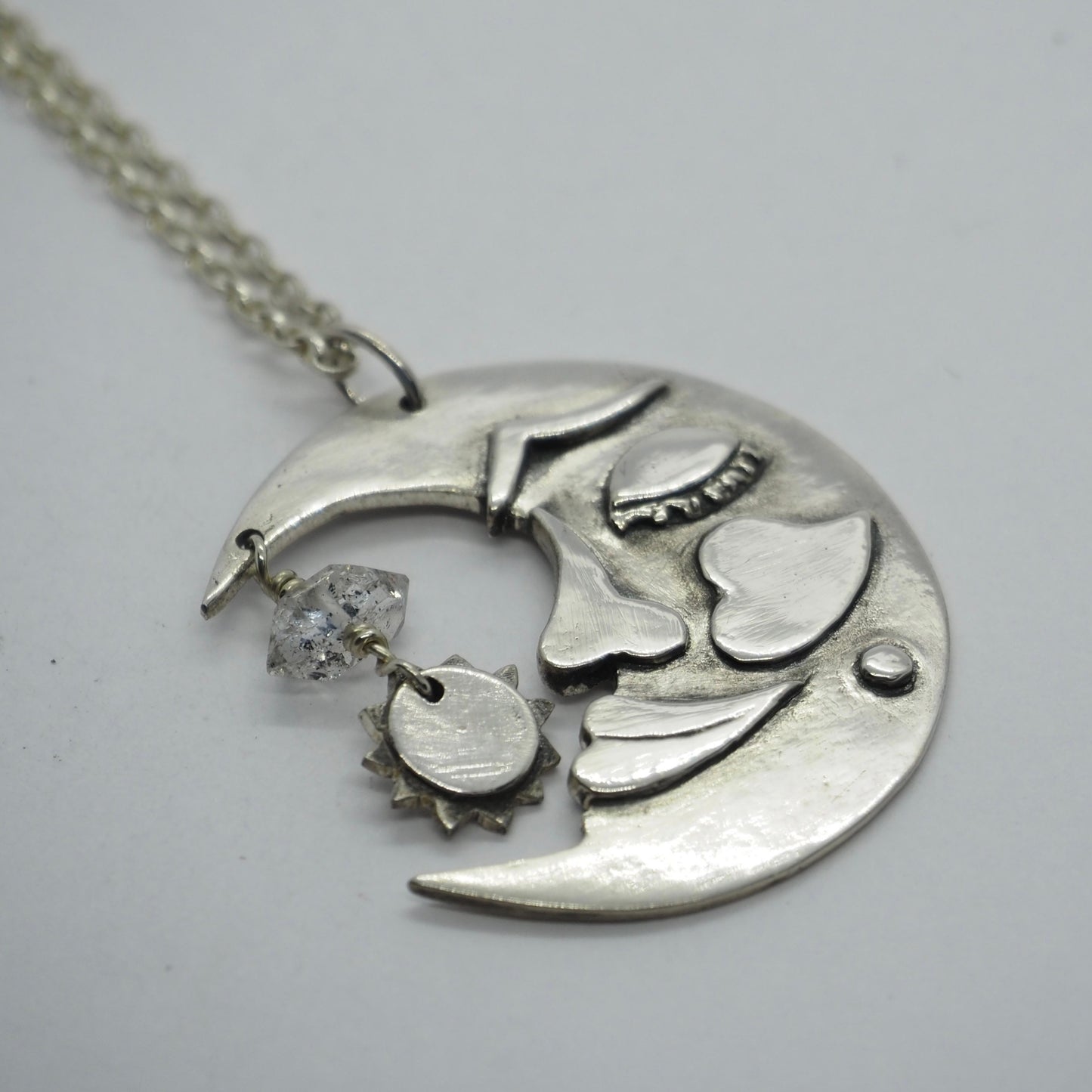 A gorgeous handmade fine silver moon and sun pendant on a sterling silver chain embellished with a Herkimer diamond…