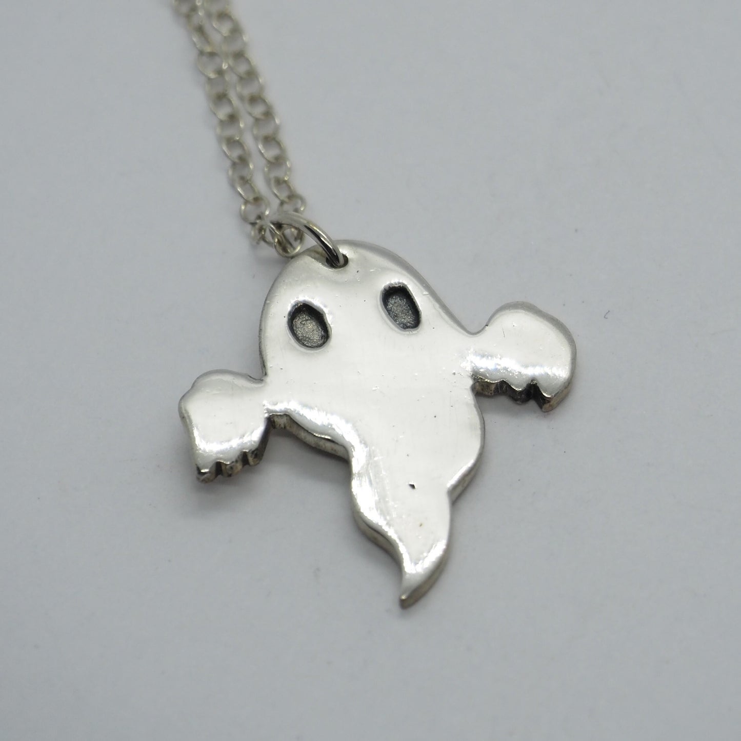 A cute little ghost pendant handmade in fine silver.