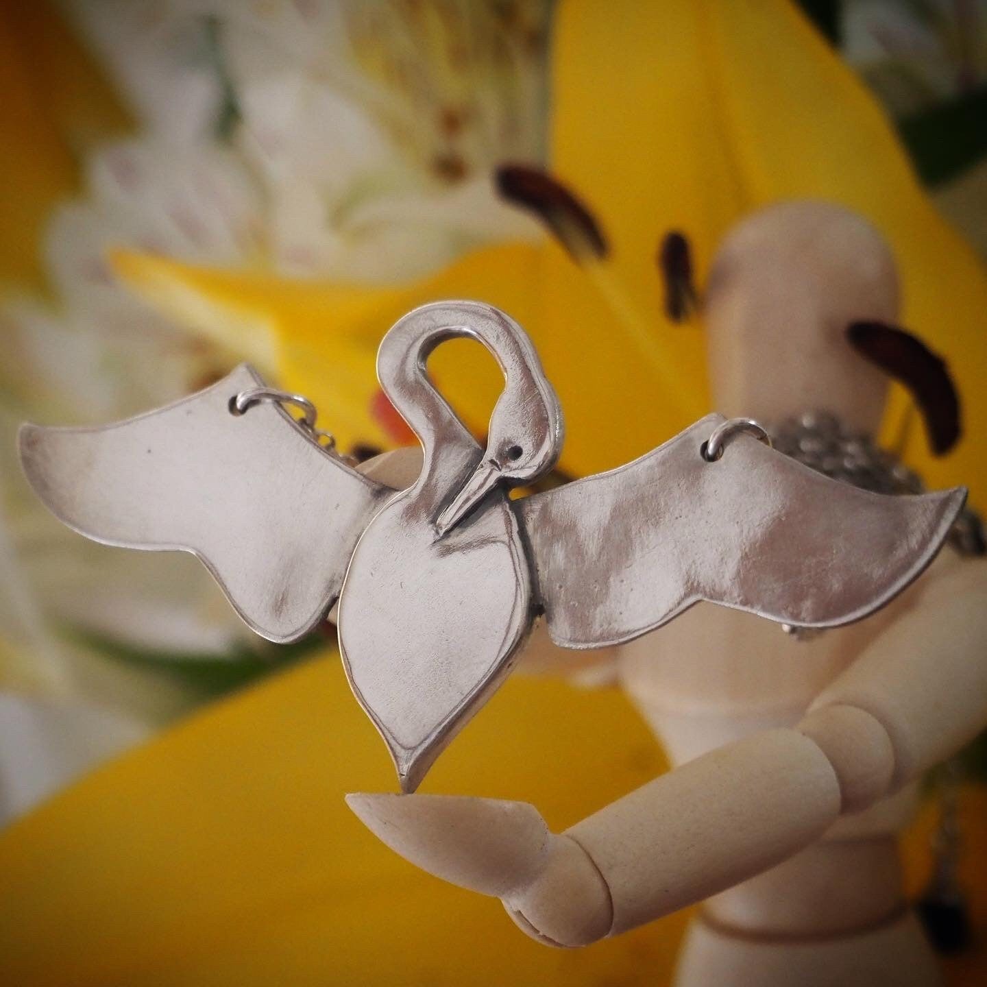 A unique and beautifully simple flying swan necklace, handmade in fine silver on a sterling silver chain.