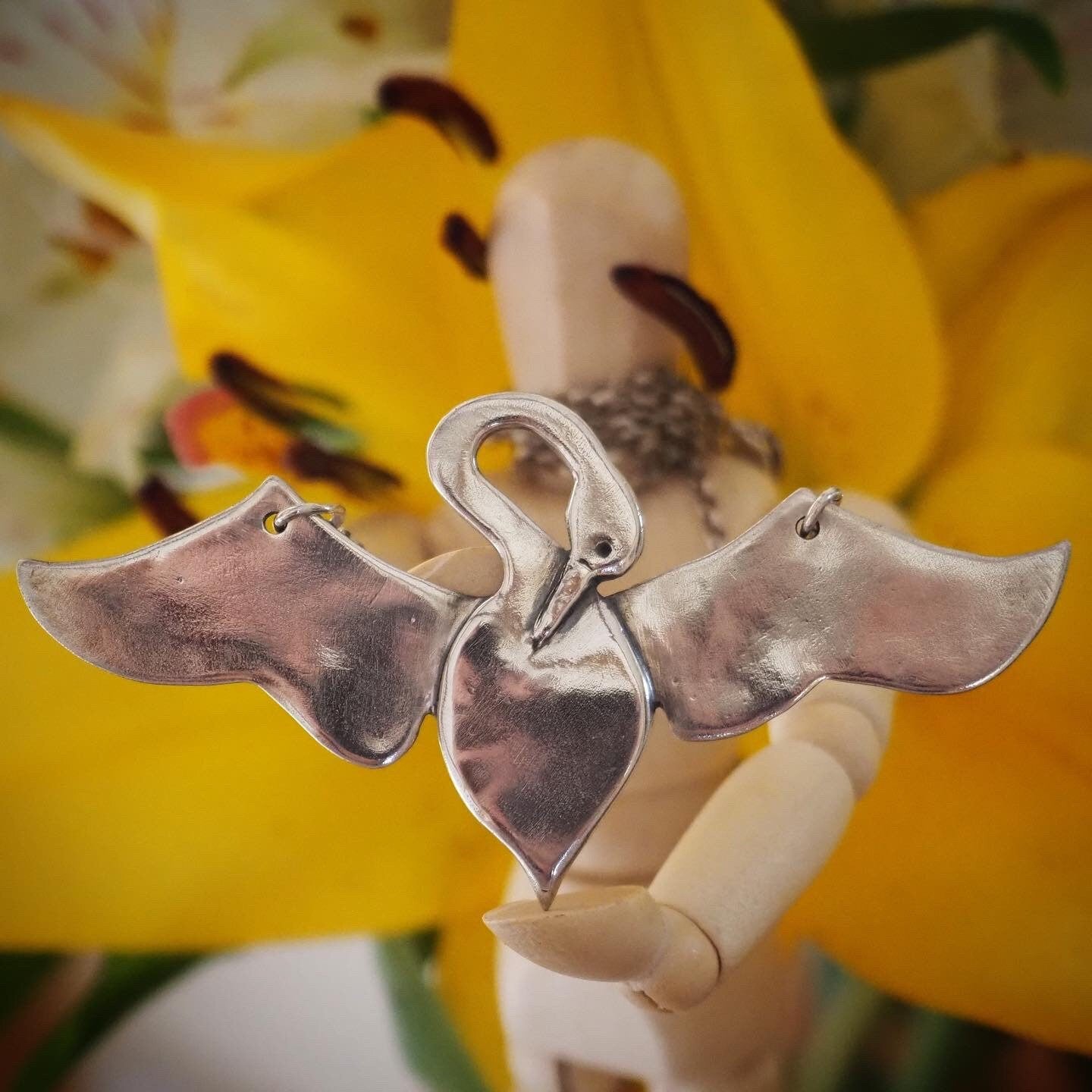 A unique and beautifully simple flying swan necklace, handmade in fine silver on a sterling silver chain.