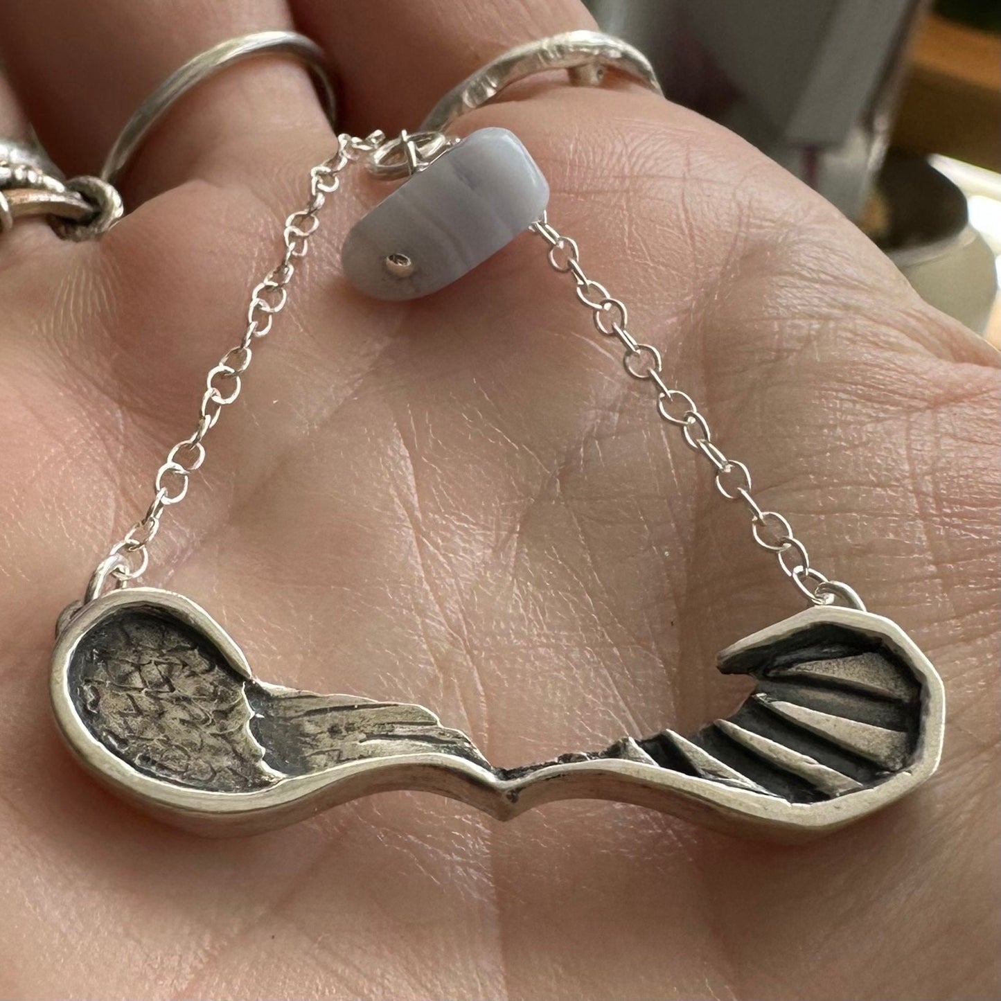 A gorgeously simple fine silver pair of handmade angel and devil wings necklace on a sterling silver chain.