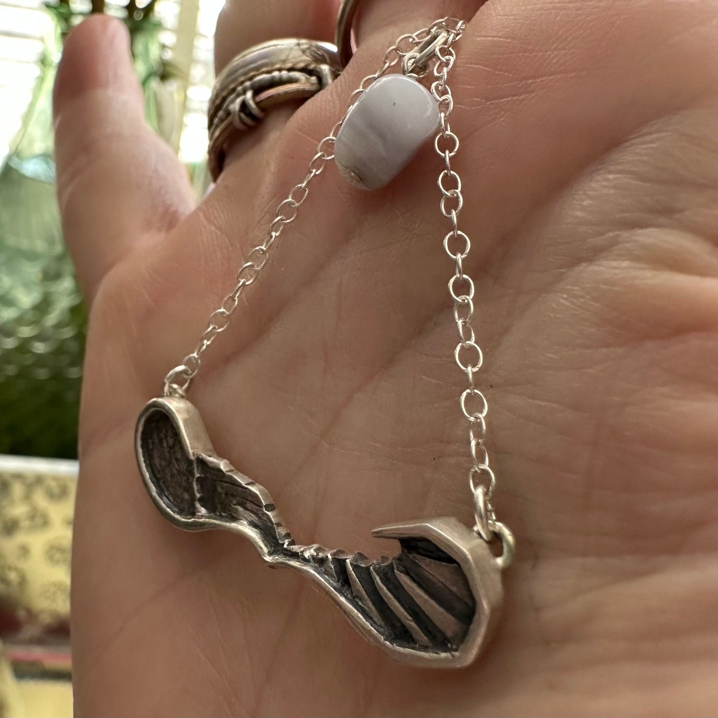 A gorgeously simple fine silver pair of handmade angel and devil wings necklace on a sterling silver chain.