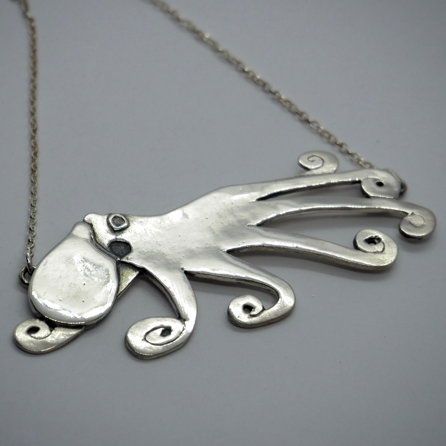 A beautiful unique hand made giant octopus fine silver pendant on a sterling silver chain.