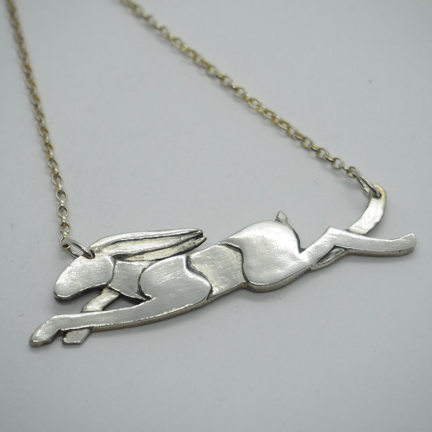 A wonderfully simple leaping hare necklace hand made in eco friendly fine silver hung on a sterling silver chain.