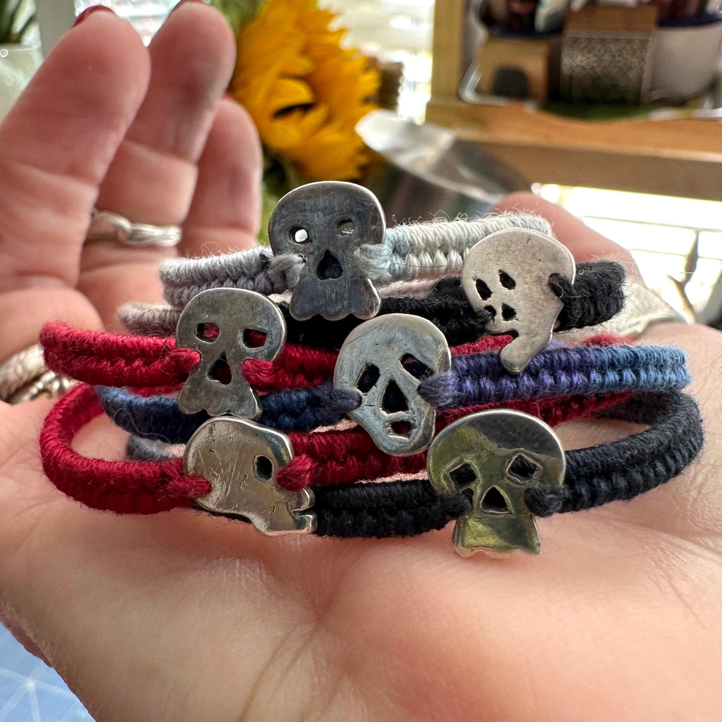 A pair of tiny little fine silver skull stud earrings on sterling silver posts.