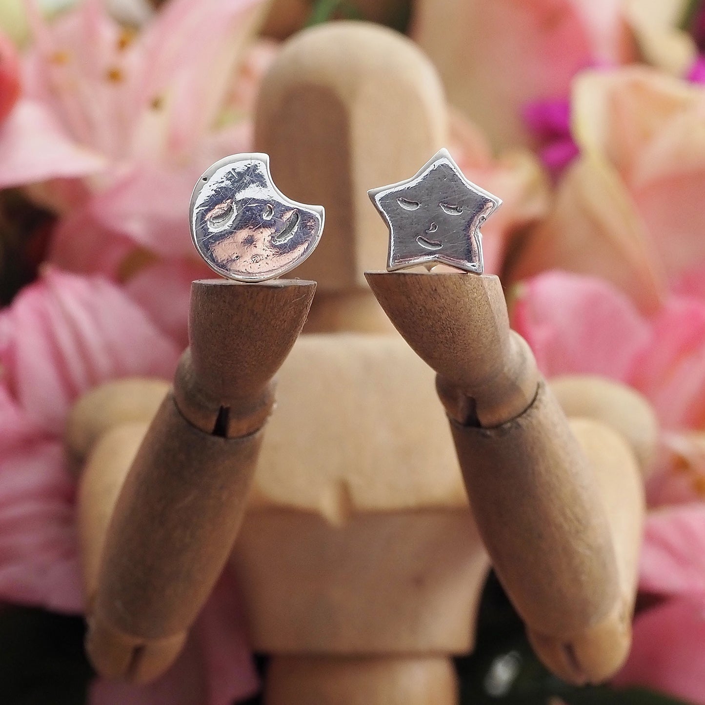 A gorgeous pair of happy smiling fine silver star and moon stud earrings on sterling silver posts.