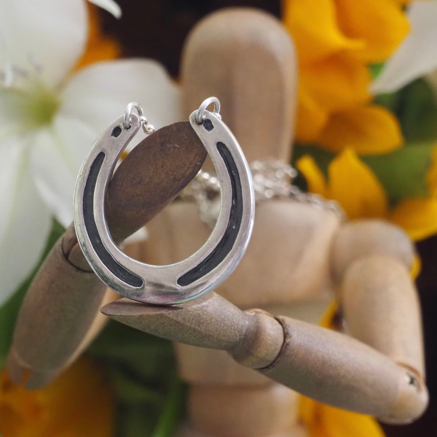 A beautiful handmade fine silver lucky horseshoe necklace on a sterling silver chain.