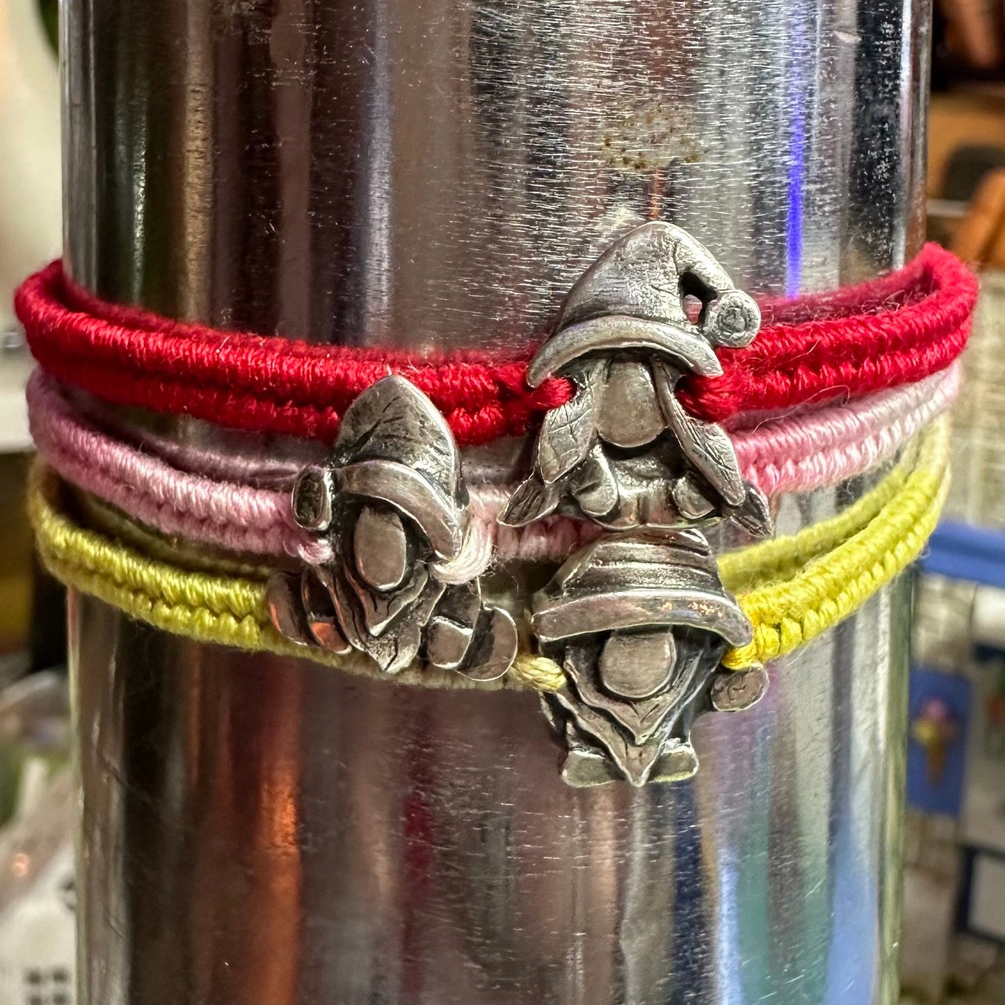 A handmade fine silver Norm nisse gnome on a pretty pink leather and cotton friendship bracelet, finished with a sterling silver bead.