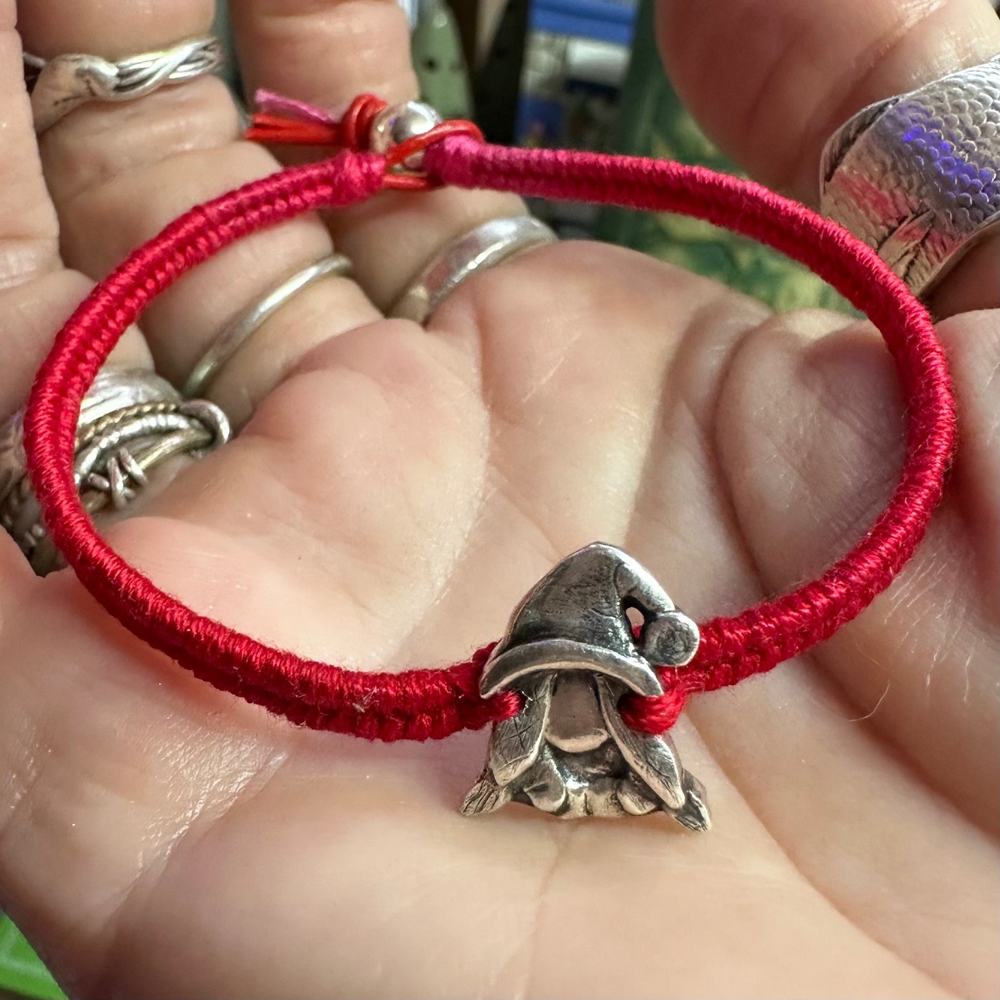 A handmade fine silver Norma nisse lady gnome on a fab red leather and cotton friendship bracelet, finished with a sterling silver bead.